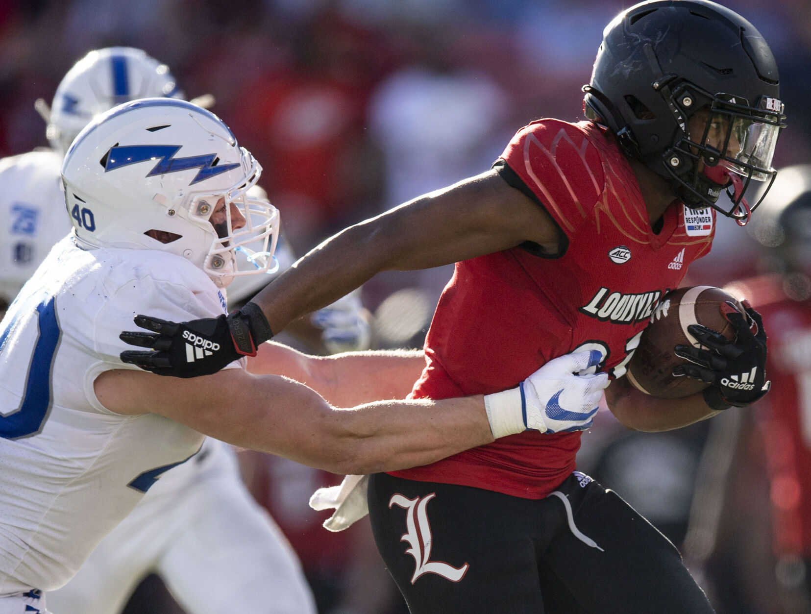 Air Force sophomore Alec Mock (40) reaches for Louisville freshman running back Trevion Cooley (23) as the Air Force Falcons take on the Louisville Cardinals during the 2021 First Responder Bowl at Gerald J. Ford Stadium on the campus of Southern Methodist University in Dallas, Texas on Tuesday, Dec. 28, 2021. The Falcons defeated the Cardinals and won the bowl game by a score of 31-28. (Chancey Bush/ The Gazette) (Chancey Bush/ The Gazette)