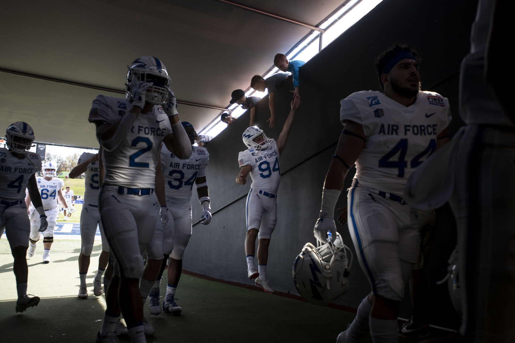 Air Force Tevye Schuettpelz-Rohl (94) high-fives young fans inside the tunnel Falcons before the start of the Air Force Falcons bowl game as they take on the Louisville Cardinals during the 2021 First Responder Bowl at Gerald J. Ford Stadium on the campus of Southern Methodist University in Dallas, Texas on Tuesday, Dec. 28, 2021. (Chancey Bush/ The Gazette) (Chancey Bush/ The Gazette)