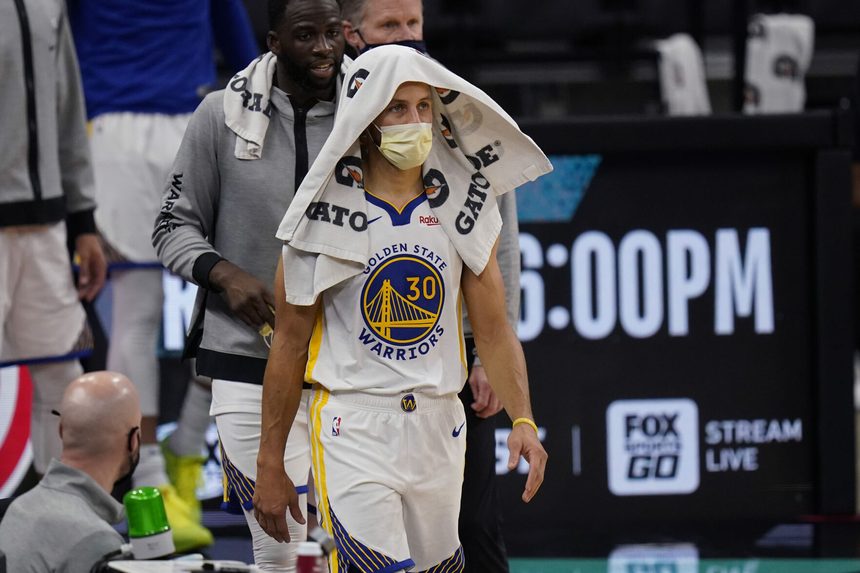 FILE -Golden State Warriors guard Stephen Curry (30) wears a face mask to protect against the spread of COVID-19 during the second half of an NBA basketball game against the San Antonio Spurs in San Antonio, Tuesday, Feb. 9, 2021. U.S. sports leagues are seeing rapidly increasing COVID-19 outbreaks with dozens of players in health and safety protocols, amid an ongoing surge by the delta variant of the coronavirus and rising cases of the highly transmissible omicron mutation. (AP Photo/Eric Gay, File) (Eric Gay)