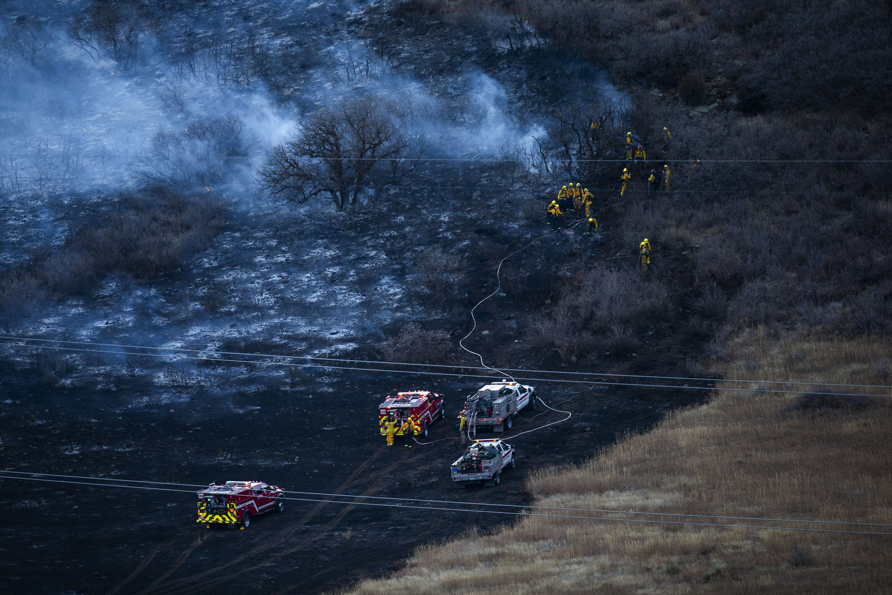 Firefighters mop up hotspots of a grassfire on the hill west of C-470 on Monday, Dec. 27, 2021, in Littleton, Colo. (Timothy Hurst/The Gazette) (Timothy Hurst)