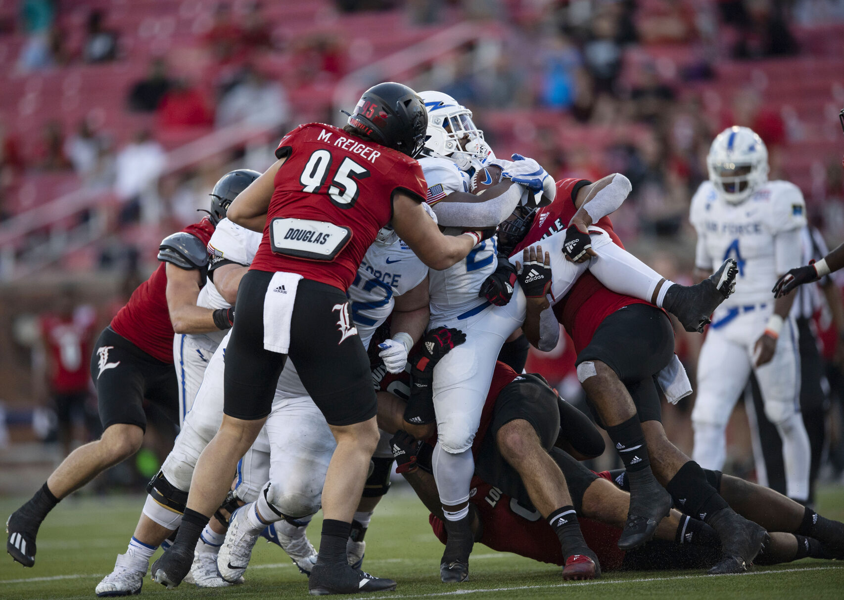 Air Force junior Emmanuel Michel (28) is closed in on as the Air Force take on the Louisville Cardinals during the 2021 First Responder Bowl at Gerald J. Ford Stadium on the campus of Southern Methodist University in Dallas, Texas on Tuesday, Dec. 28, 2021. The Falcons defeated the Cardinals and won the bowl game by a score of 31-28. (Chancey Bush/ The Gazette) (Chancey Bush/ The Gazette)