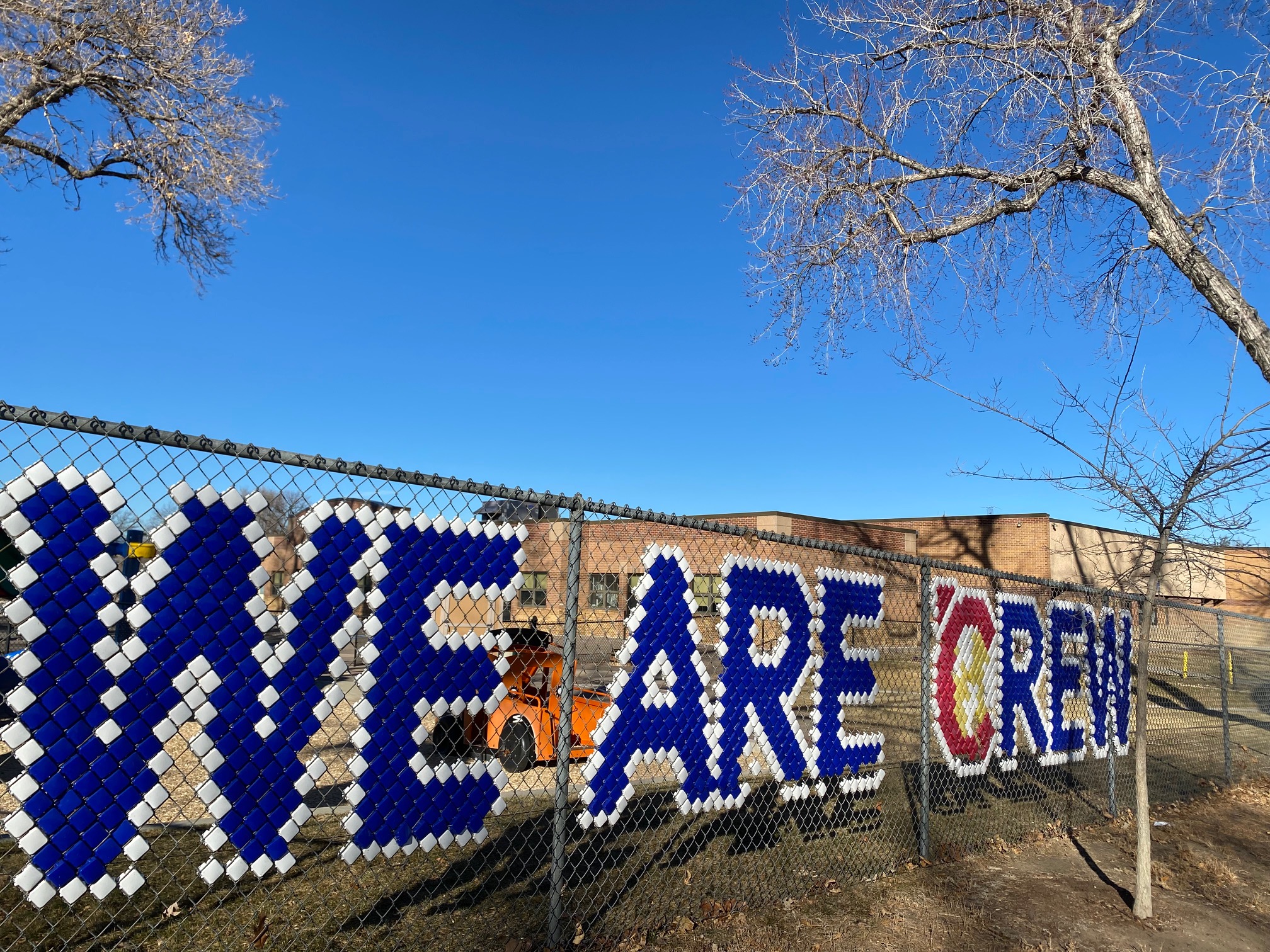 Hand-made sign woven into the playground fence at Centennial Elementary. (Carol McKinley)