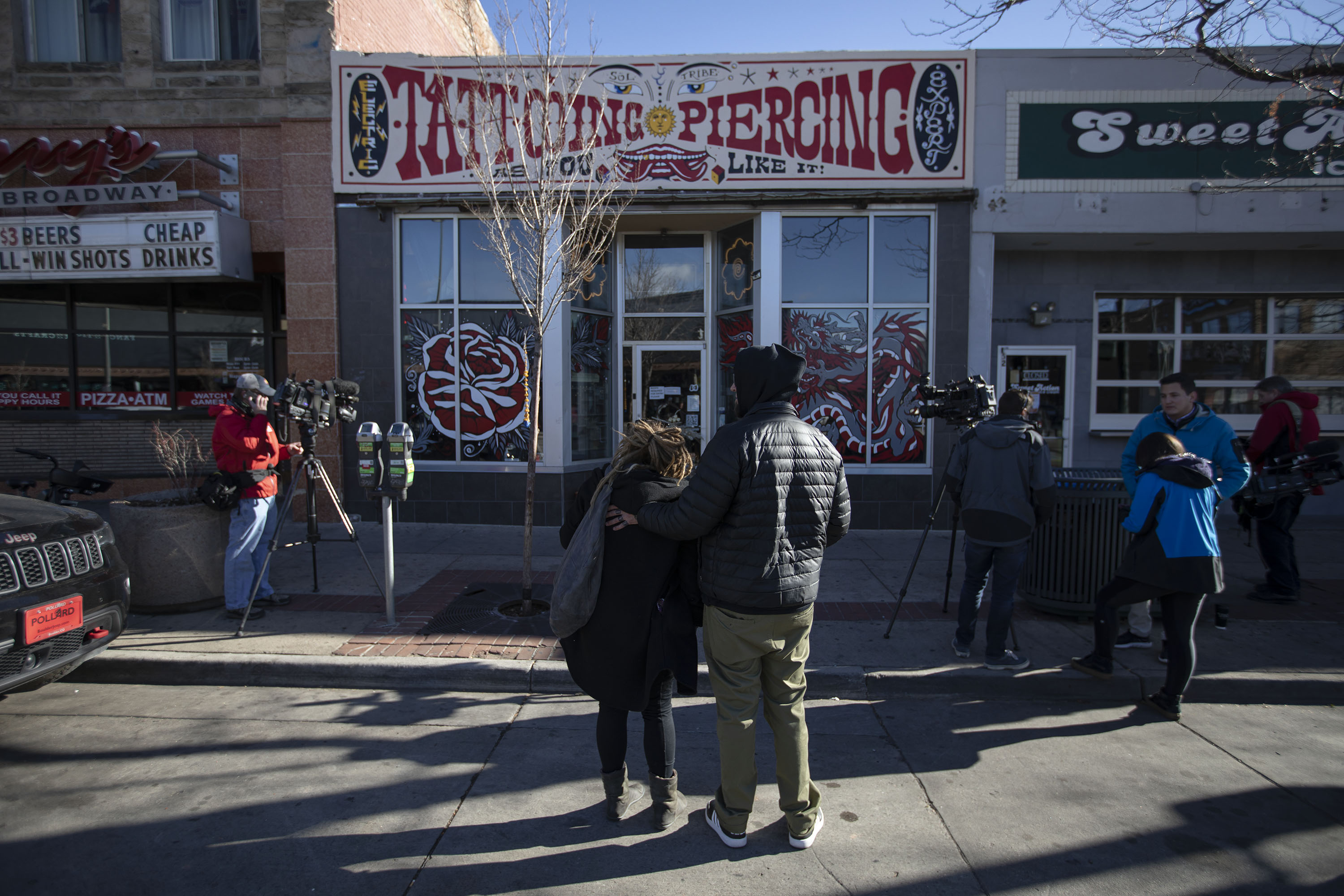 Two people console each other in front of Sol Tribe Tattoo & Piercing, which was owned by Alicia Cardenas, one of the victims of a shooting spree the previous night, as seen on Tuesday, Dec. 28, 2021, in Denver, Colo. (Timothy Hurst/The Gazette) (Timothy Hurst)