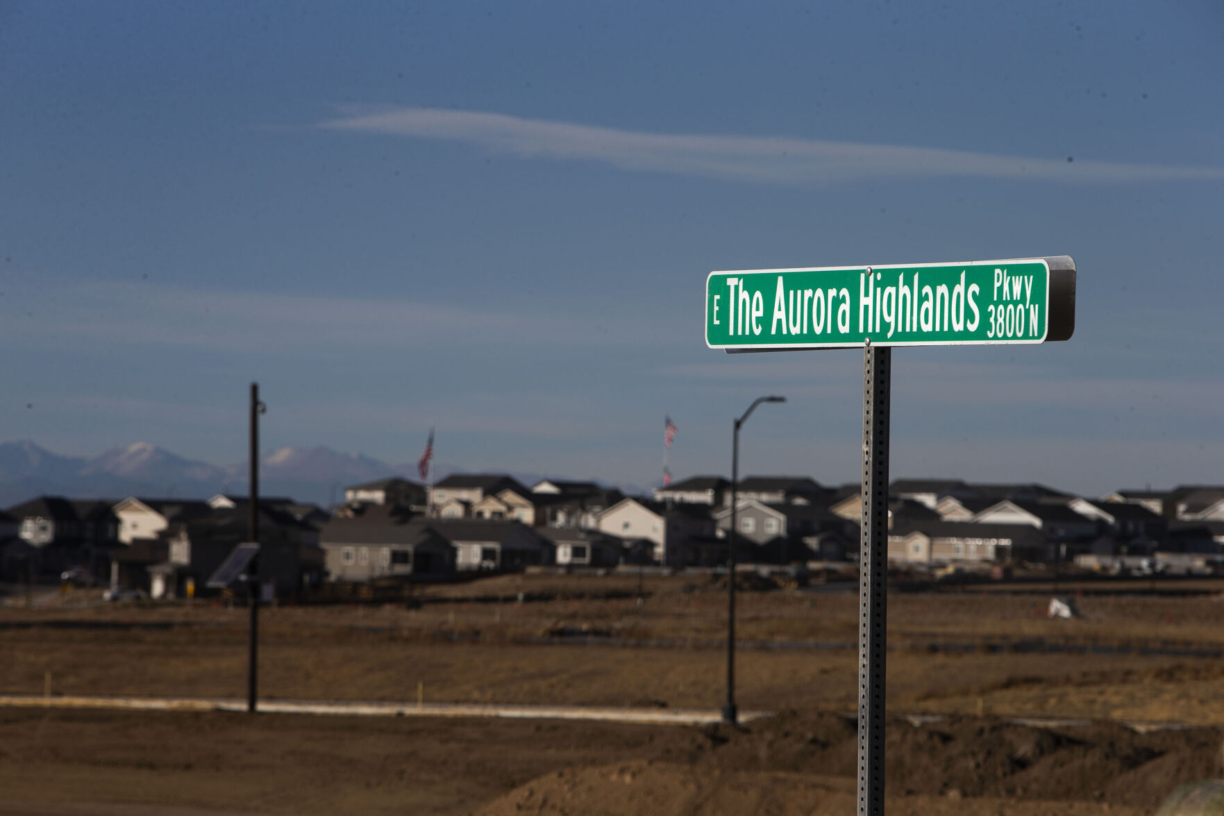 Currently built and still-under-construction houses can be seen across open fields from a street sign on Thursday, Dec. 2, 2021, in the Aurora Highlands Metro District in Aurora, Colo. (Timothy Hurst/The Gazette) (Timothy Hurst, The Gazette)