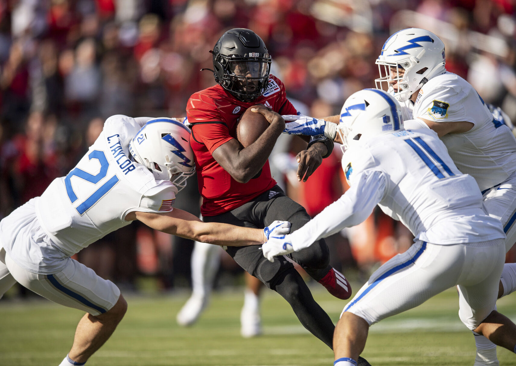 Air Force senior Corvan Taylor (21) sophomore Camby Goff (11) and sophomore Bo Richter (31) take down Louisville junior quarterback Malik Cunningham (3) as the Air Force Falcons take on the Louisville Cardinals during the 2021 First Responder Bowl at Gerald J. Ford Stadium on the campus of Southern Methodist University in Dallas, Texas on Tuesday, Dec. 28, 2021. The Falcons defeated the Cardinals and won the bowl game by a score of 31-28. (Chancey Bush/ The Gazette) (Chancey Bush/ The Gazette)
