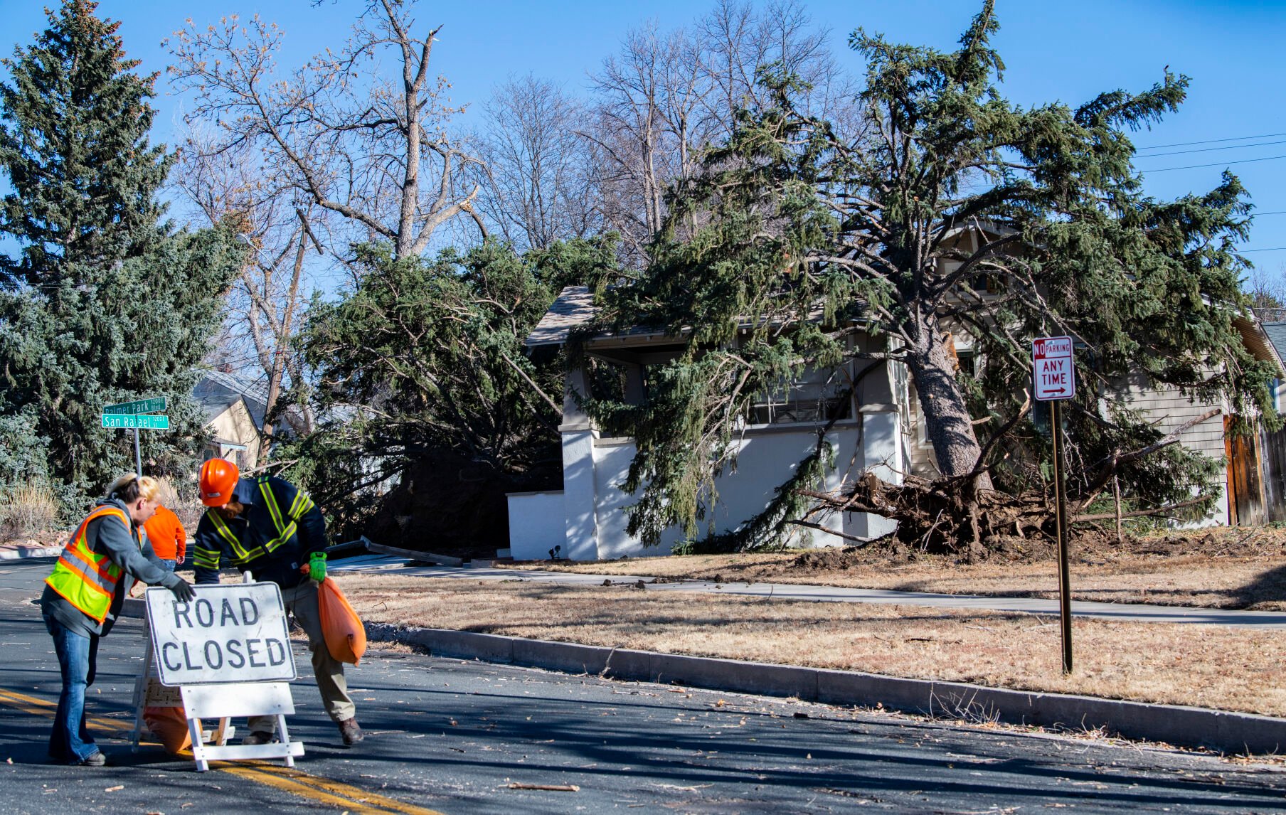 A crew from Colorado Springs Utilities closes Palmer Park Blvd. near Hancock Avenue after high winds knocked down power lines and blew three evergreen trees into the house in the background Wednesday, Dec. 15, 2021. The storm brought Colorado Springs wind gusts more than 100 mph. (The Gazette, Christian Murdock) (Christian Murdock/The Gazette)
