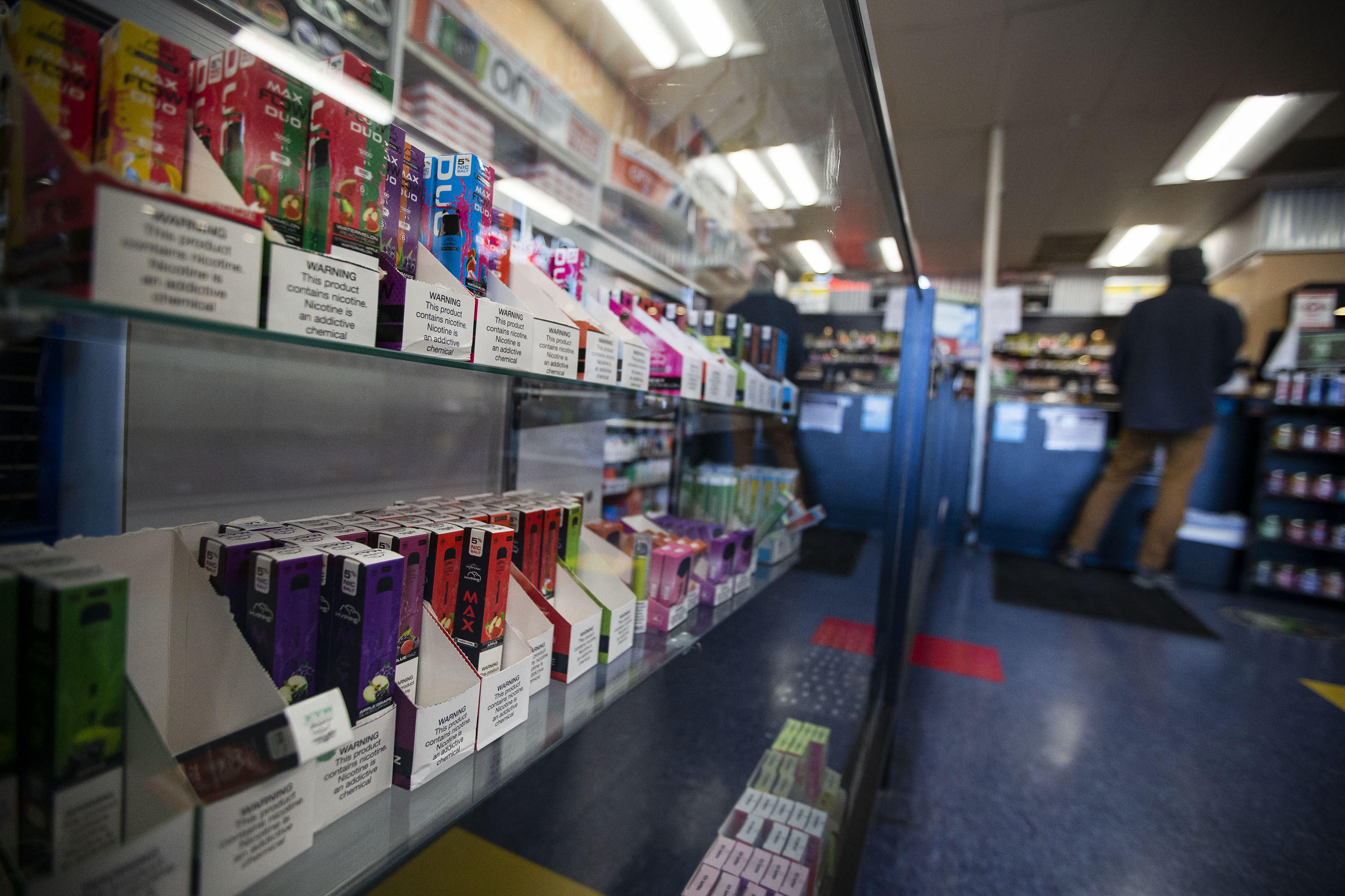 Bottles of nicotine e-liquid can be seen in the display cases as a customer checks out at Smoker Friendly on South Broadway on Tuesday, Dec. 7, 2021, in Denver, Colo. (Timothy Hurst/The Gazette) (Timothy Hurst)