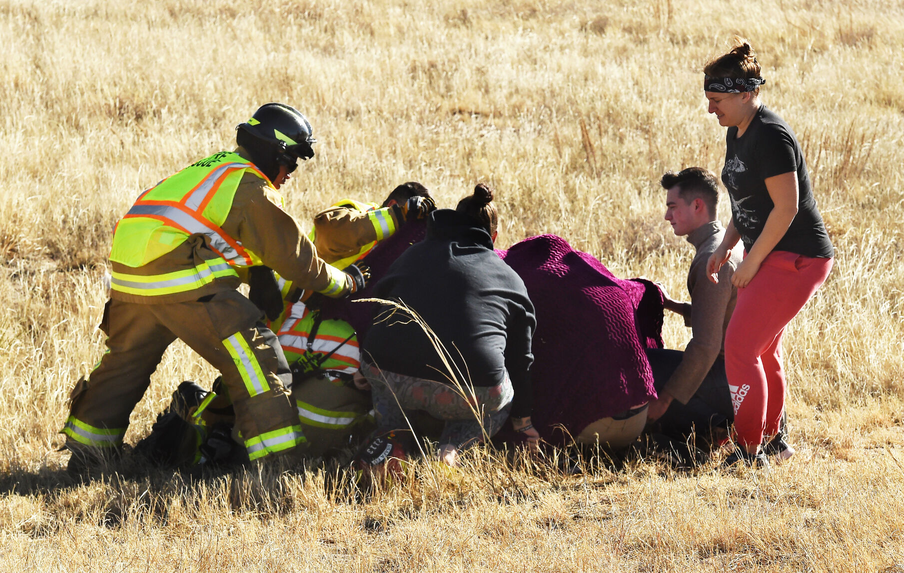 Paramedics tend to an injured person on the onramp of I-25 north of N. Academy Blvd.. Over a dozen semi trucks were blown over by high winds in the Pikes Peak region on I-25. (Photo by Jerilee Bennett, The Gazette) (Jerilee Bennett)