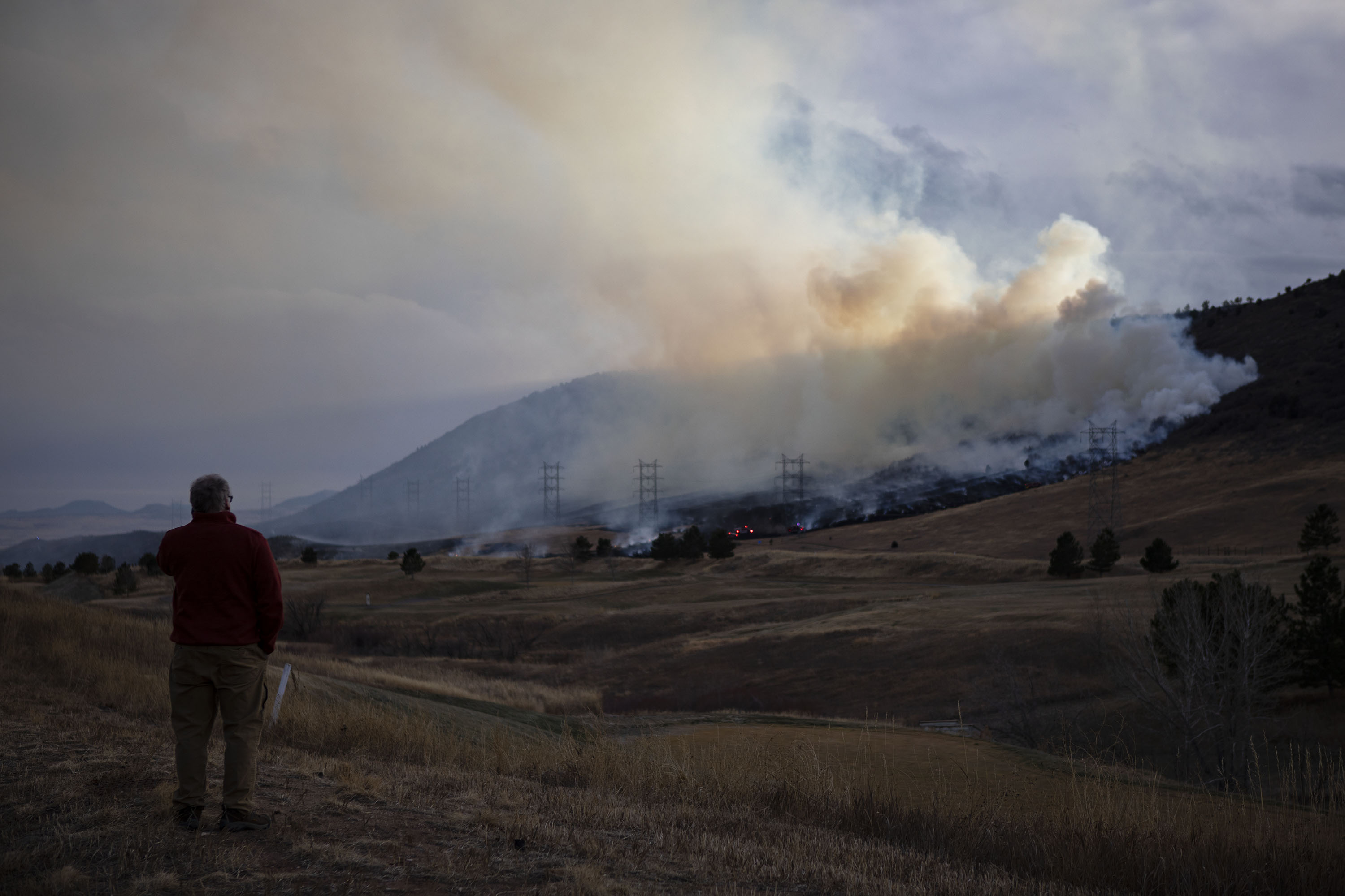 Mark Speckman watches as a plume of smoke rises from a wildfire on the hill west of C-470 on Monday, Dec. 27, 2021, in Littleton, Colo. (Timothy Hurst/The Gazette) (Timothy Hurst)