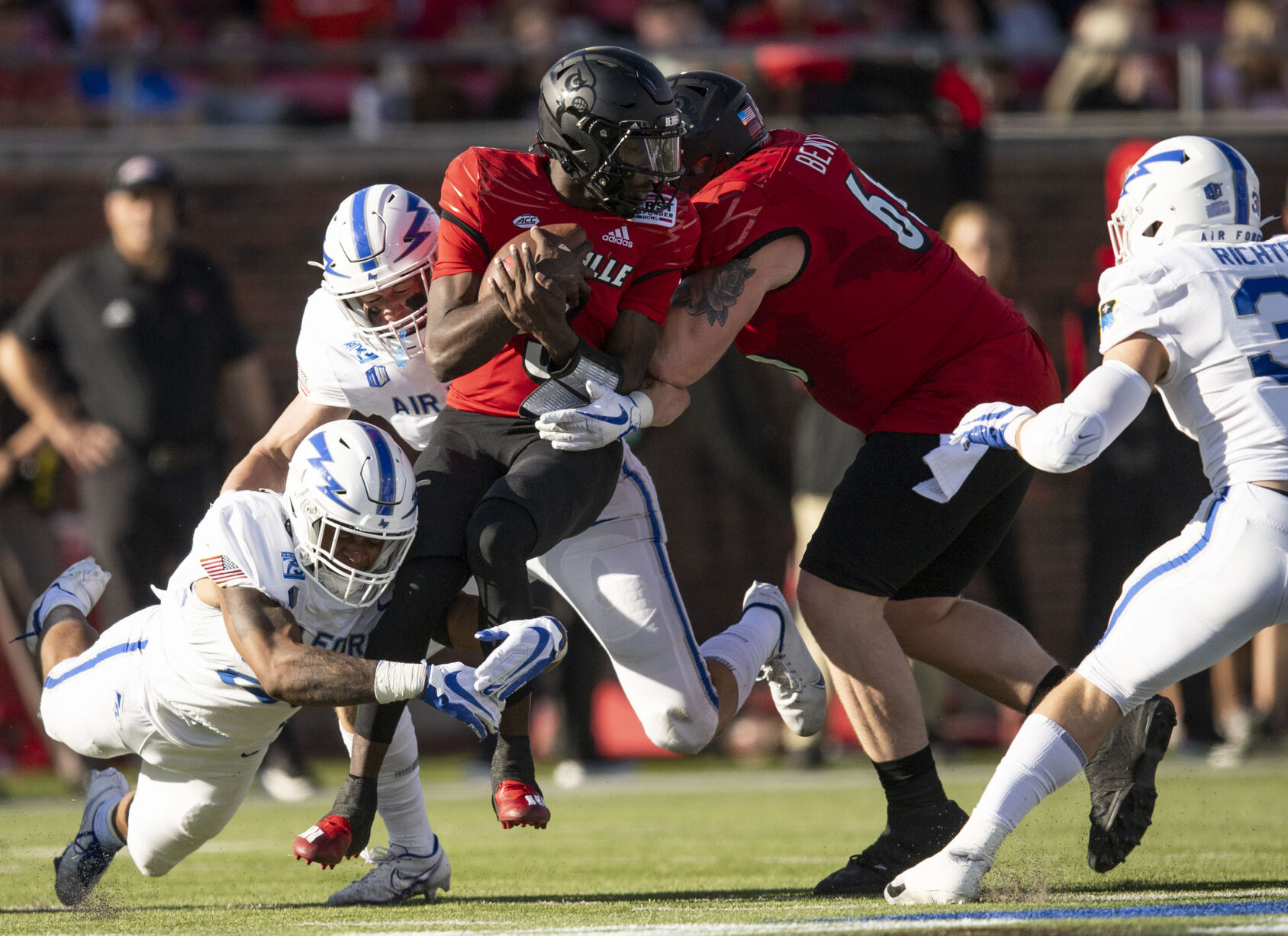 Air Force junior Vince Sanford (26) takes down Louisville junior quarterback Malik Cunningham (3) at the legs as the Air Force Falcons take on the Louisville Cardinals during the 2021 First Responder Bowl at Gerald J. Ford Stadium on the campus of Southern Methodist University in Dallas, Texas on Tuesday, Dec. 28, 2021. The Falcons defeated the Cardinals and won the bowl game by a score of 31-28. (Chancey Bush/ The Gazette) (Chancey Bush/ The Gazette)