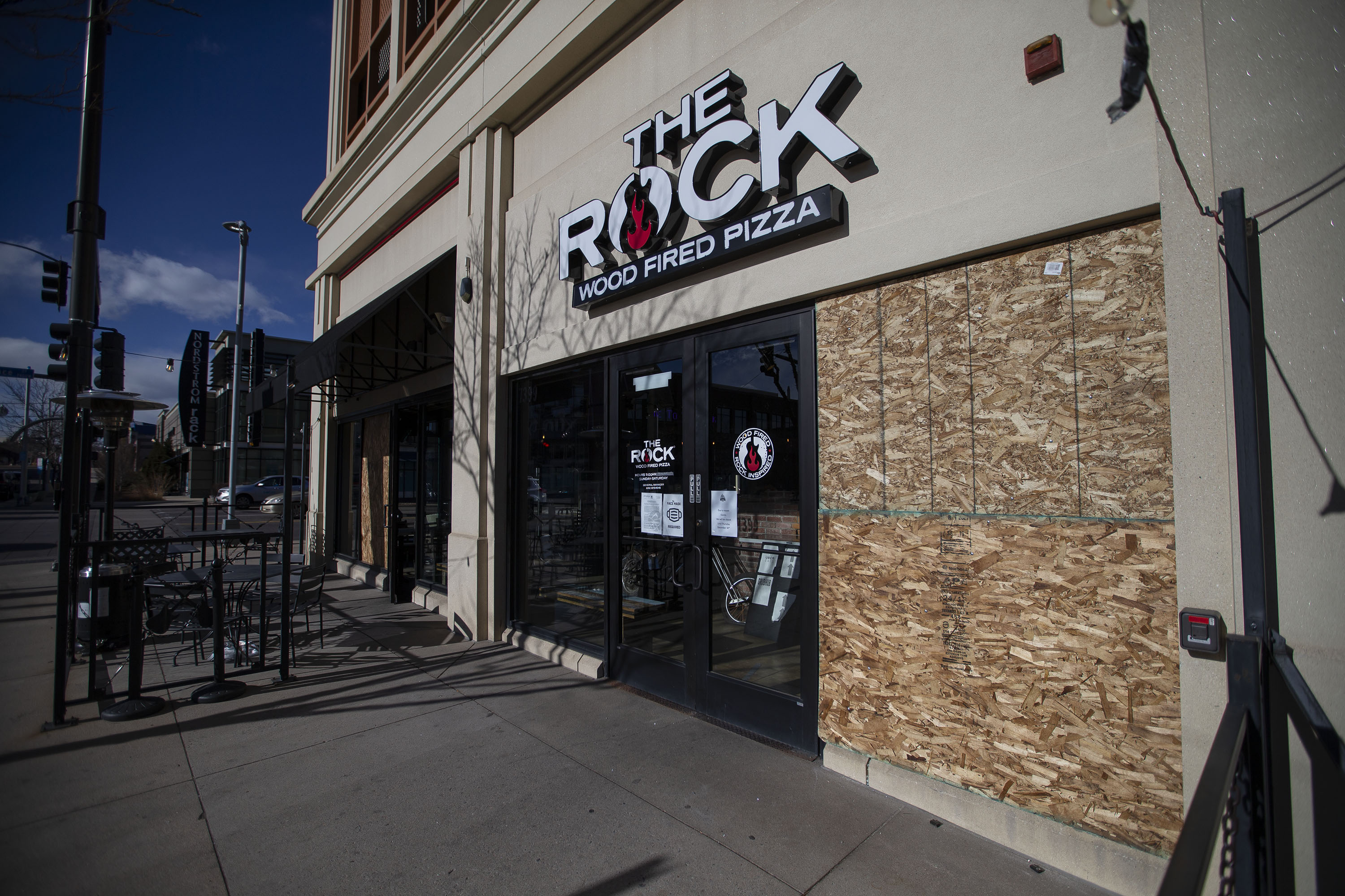 Windows are boarded up after being broken in a shooting spree the night before at The Rock Wood Fired Pizza restaurant at South Vance Street and West Alaska Drive on Tuesday, Dec. 28, 2021, in Lakewood, Colo. (Timothy Hurst/The Gazette) (Timothy Hurst)