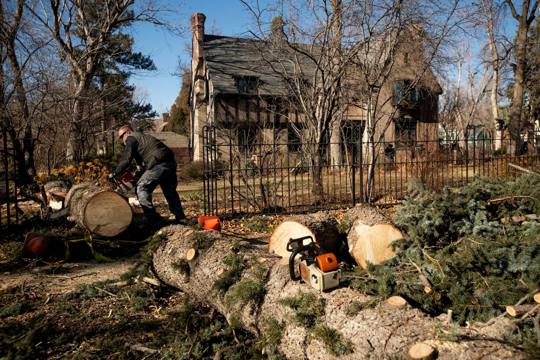 Baruch Bachofer uses a chain saw to cut into a large tree that fell outside a home on Cascade Avenue in Colorado Springs on Thursday, Dec. 16, 2021. A wind storm ripped through El Paso County causing major damages to trees, homes, sidewalks and power lines. City crews and tree companies are working to clean up the aftermath of Wednesday’s hurricane-force winds that topped 100 mph in some areas of El Paso County. Colorado Springs Utilities’ crews are working around the clock to fix utility lines and restore power to residents still facing outages in areas. (Chancey Bush/ The Gazette) (Chancey Bush/ The Gazette)