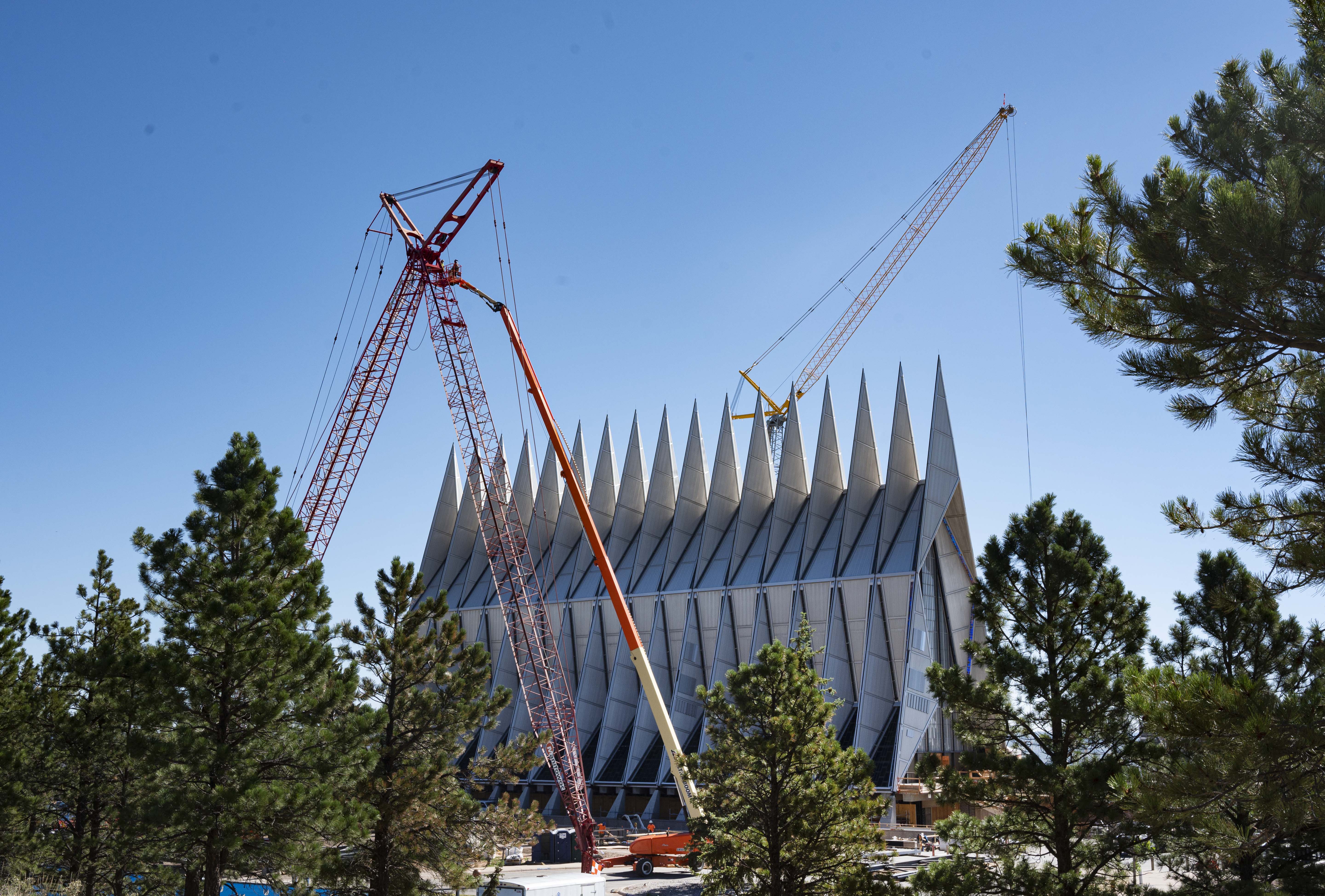 On Aug. 7, 2020, crews work on the cranes used to construct a large hangar, similar to the structure at Denver International Airport, over the U.S. Air Force Academy Cadet Chapel as part of the complete restoration and renovation of the chapel designed by American Architect Walter Netsch. (Christian Murdock, The Gazette)