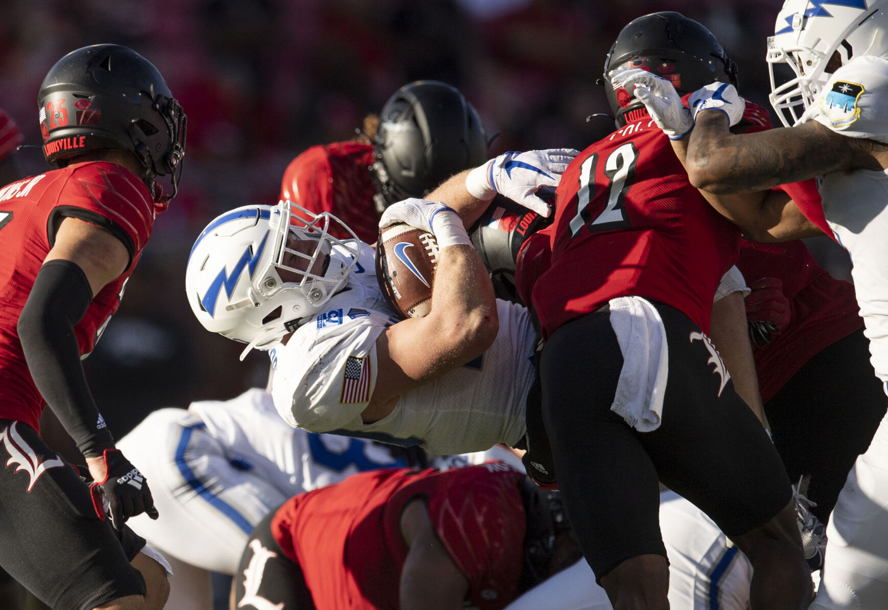 Air Force junior Brad Roberts (20) gets taken down as the Air Force Falcons take on the Louisville Cardinals during the 2021 First Responder Bowl at Gerald J. Ford Stadium on the campus of Southern Methodist University in Dallas, Texas on Tuesday, Dec. 28, 2021. The Falcons defeated the Cardinals and won the bowl game by a score of 31-28. (Chancey Bush/ The Gazette) (Chancey Bush/ The Gazette)