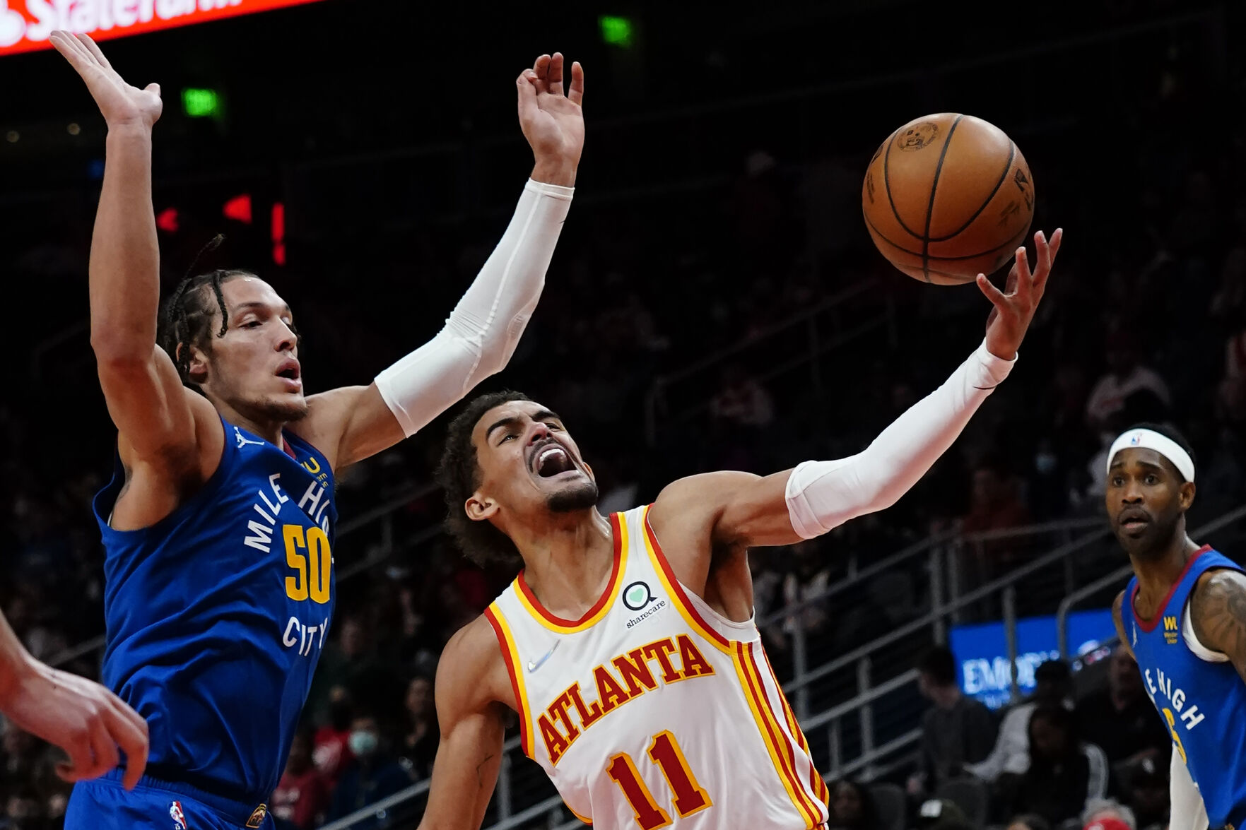 Atlanta Hawks guard Trae Young (11) goes past Denver Nuggets forward Aaron Gordon (50) during the first half of an NBA basketball game Friday, Dec. 17, 2021, in Atlanta. (AP Photo/John Bazemore) (John Bazemore)