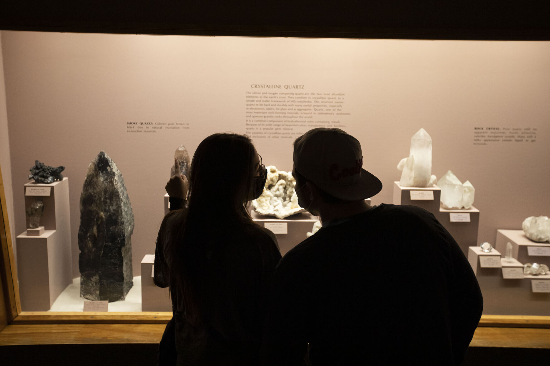 Marie Salazar and Fox Strader look through an exhibit of various quartz specimens at the Denver Museum of Nature and Science. (Timothy Hurst)