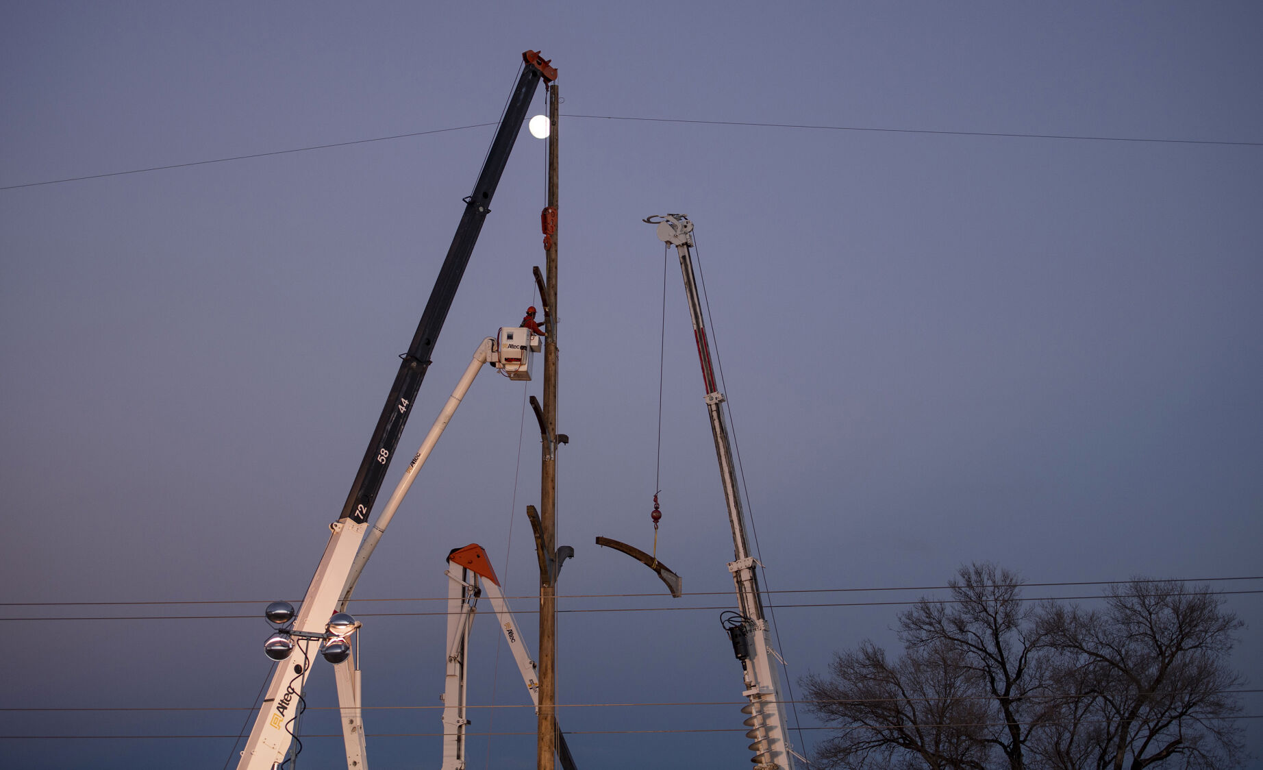 A lineman works to fix Colorado Springs Utilities’ poles along Nevada Avenue to restore power to residents without electricity in Colorado Springs on Thursday, Dec. 16, 2021. A wind storm ripped through El Paso County causing major damages to trees, homes, sidewalks and power lines. City crews and tree companies are working to clean up the aftermath of Wednesday’s hurricane-force winds that topped 100 mph in some areas of El Paso County. Colorado Springs Utilities’ crews are working around the clock to fix utility lines and restore power to residents still facing outages in areas. (Chancey Bush/ The Gazette) (Chancey Bush/ The Gazette)