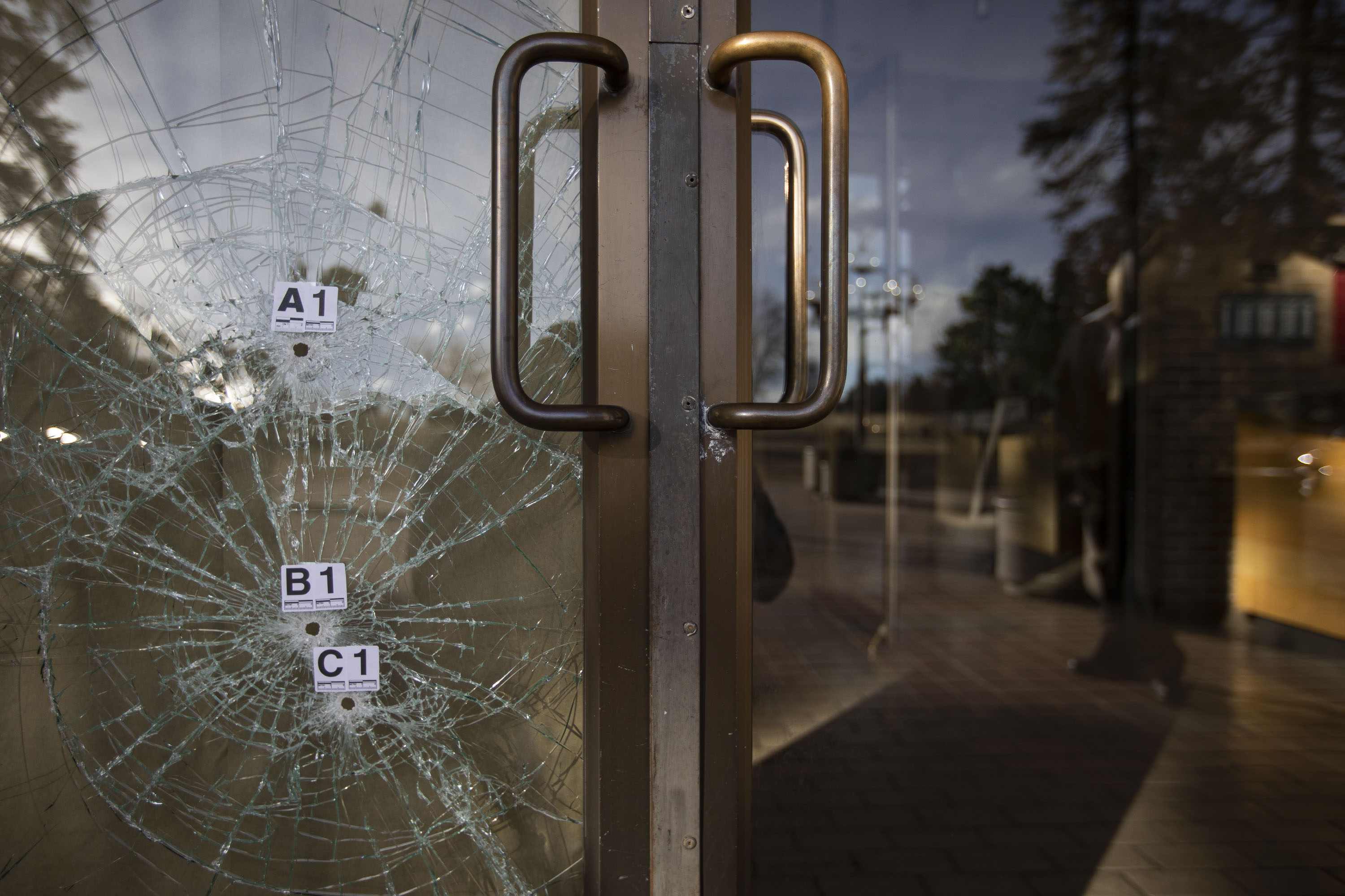 Bullet holes with evidence markers are in the front doors of 1201 Williams Street from a shooting spree the previous night, as seen on Tuesday, Dec. 28, 2021, in Denver, Colo. (Timothy Hurst/The Gazette) (Timothy Hurst)