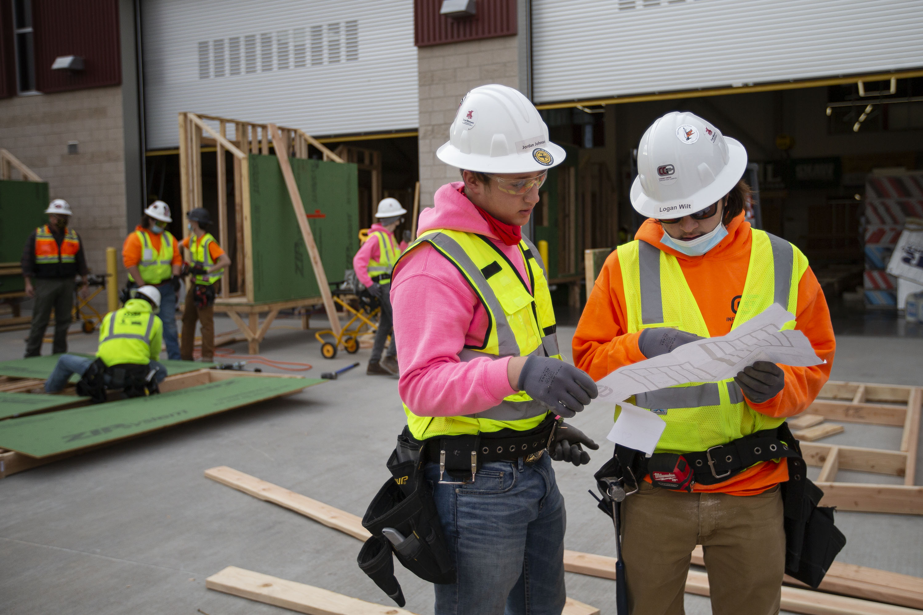 Eagle Crest junior Jordan Johnson, left, and Cherokee Trail junior Logan Wilt go over schematics while framing walls for tiny houses on Thursday, Dec. 9, 2021, at the Cherry Creek Innovation Campus in Centennial, Colo. (Timothy Hurst/The Gazette) (Timothy Hurst)