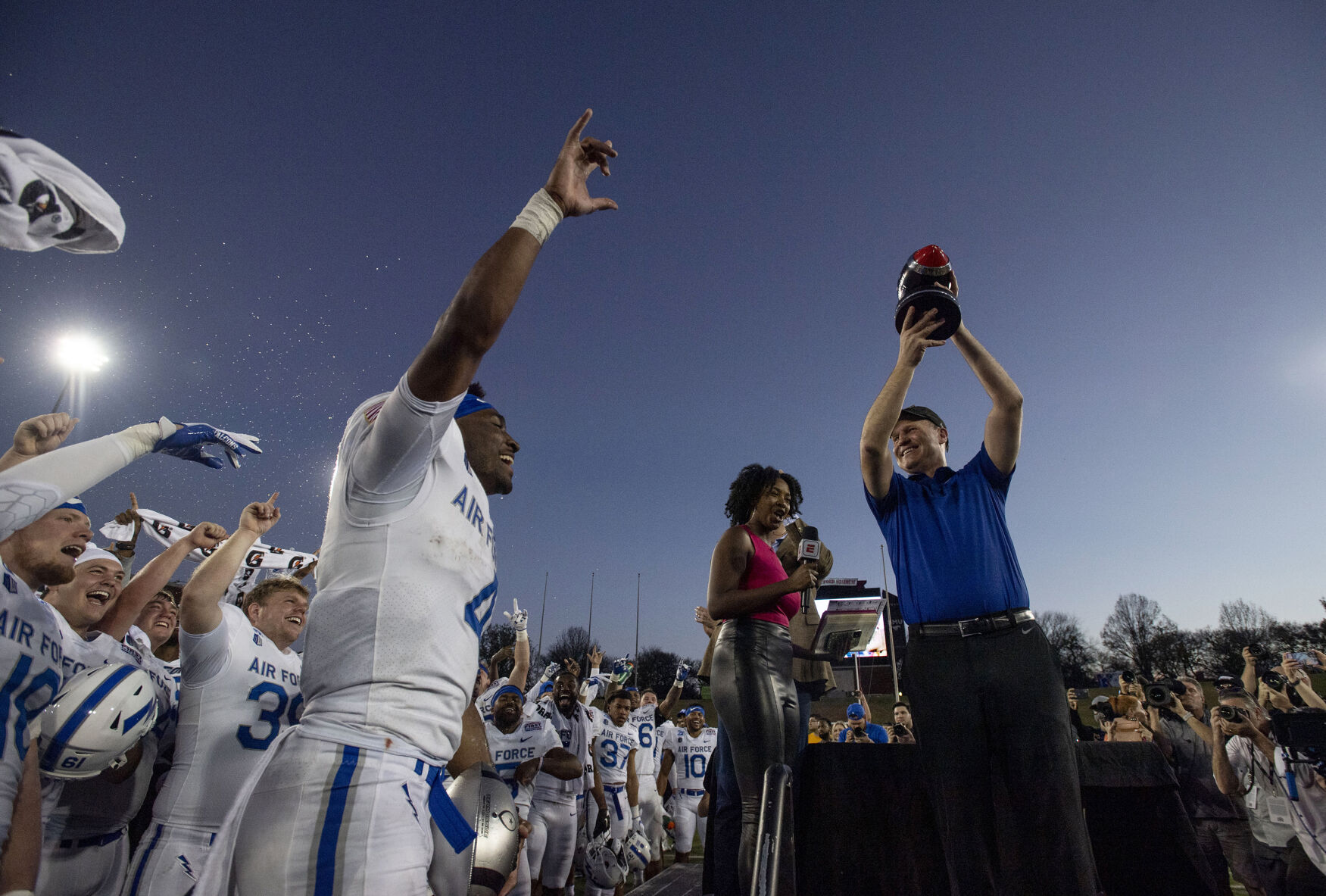 Air Force head coach Troy Calhoun celebrates with the team and MVP senior quarterback Haaziq Daniels, center, as he holds up their trophy after the Air Force Falcons defeat the Louisville Cardinals during the 2021 First Responder Bowl at Gerald J. Ford Stadium on the campus of Southern Methodist University in Dallas, Texas on Tuesday, Dec. 28, 2021. The Falcons defeated the Cardinals and won the bowl game by a score of 31-28. (Chancey Bush/ The Gazette) (Chancey Bush/ The Gazette)