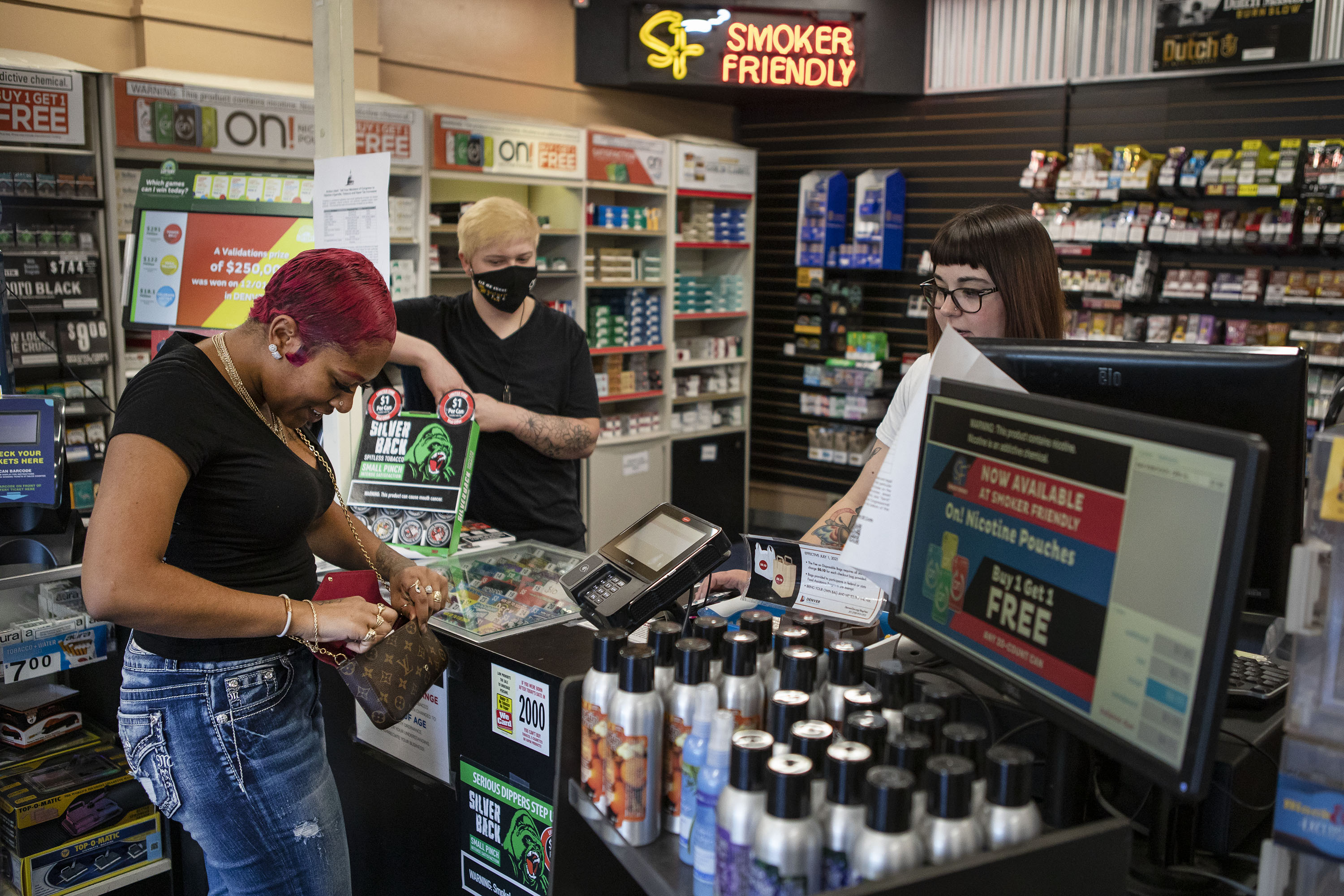 Customer Andrea Allen checks out with sales associate Josie B. while buying flavored cigars at Smoker Friendly on South Broadway on Tuesday, Dec. 7, 2021, in Denver, Colo. (Timothy Hurst/The Gazette) (Timothy Hurst)
