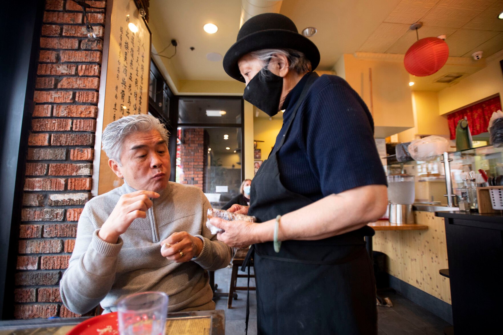 Edwin Zoe tastes a piece of pork belly prepared by his mother Anna Zoe, who is known as Ma Ma, 78, at their restaurant Zoe Ma Ma in Boulder in October. (Chancey Bush, The Gazette)