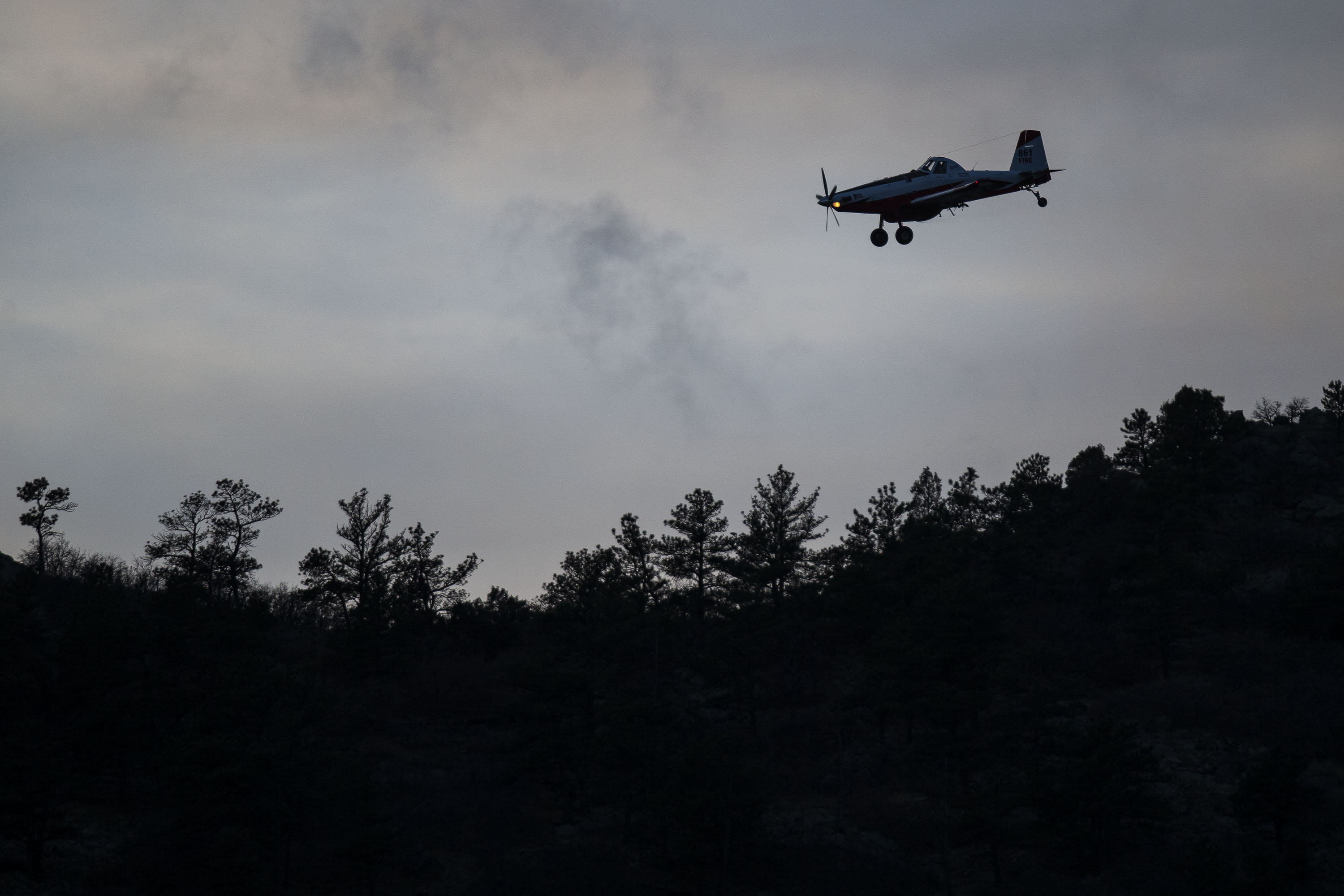 A single engine air tanker circles the air above a grassfire on the hill west of C-470 before returning to make a drop on Monday, Dec. 27, 2021, in Littleton, Colo. (Timothy Hurst/The Gazette) (Timothy Hurst)