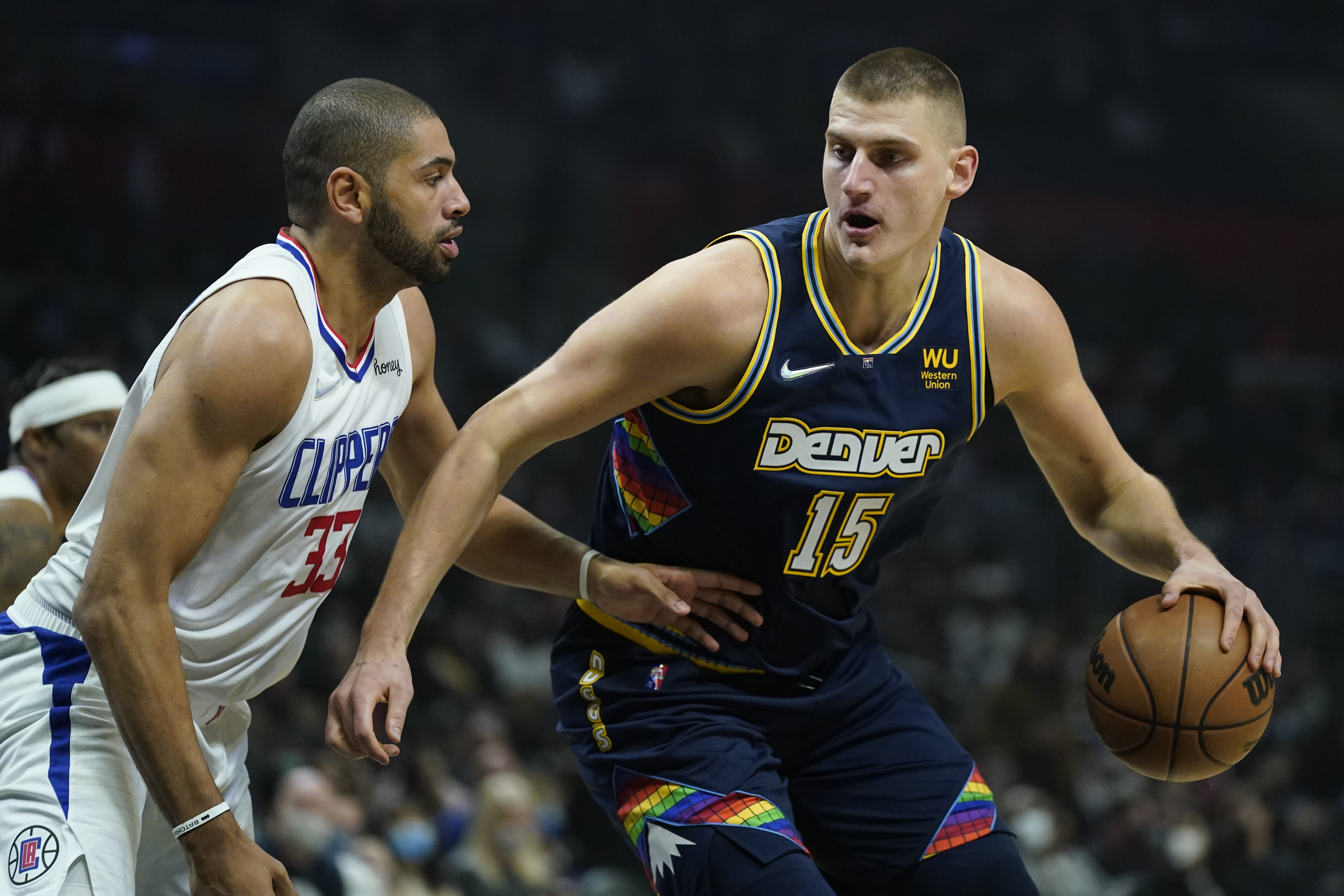 Los Angeles Clippers forward Nicolas Batum (33) defends against Denver Nuggets center Nikola Jokic (15) during the first half of an NBA basketball game in Los Angeles, Sunday, Dec. 26, 2021. (AP Photo/Ashley Landis) (Ashley Landis)