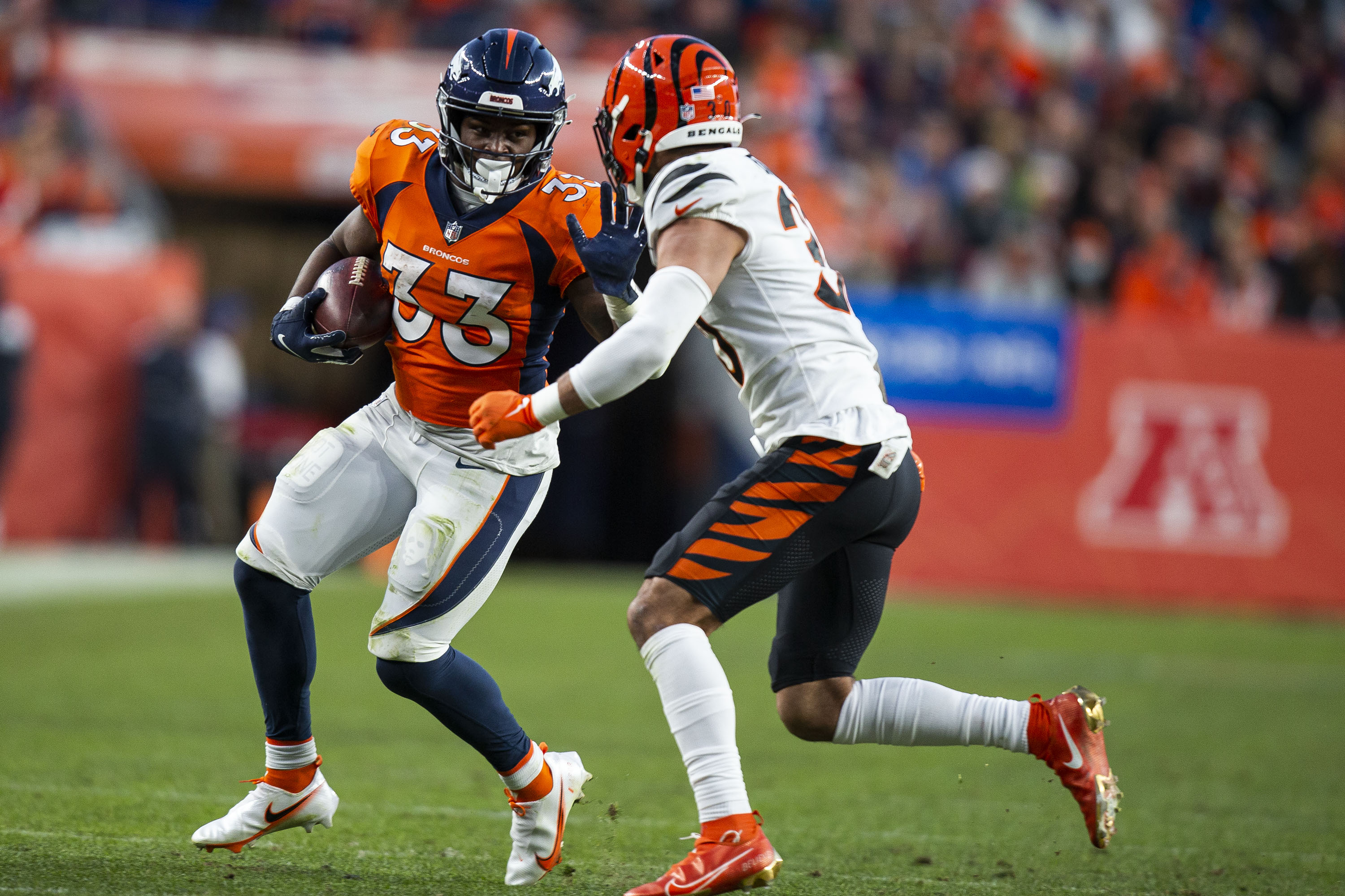 Denver Broncos running back Javonte Williams (33) looks to stiff arm Cincinnati Bengals safety Jessie Bates III (30) on Sunday, Dec. 19, 2021, at Empower Field at Mile High in Denver, Colo. (Timothy Hurst/The Gazette) (Timothy Hurst)