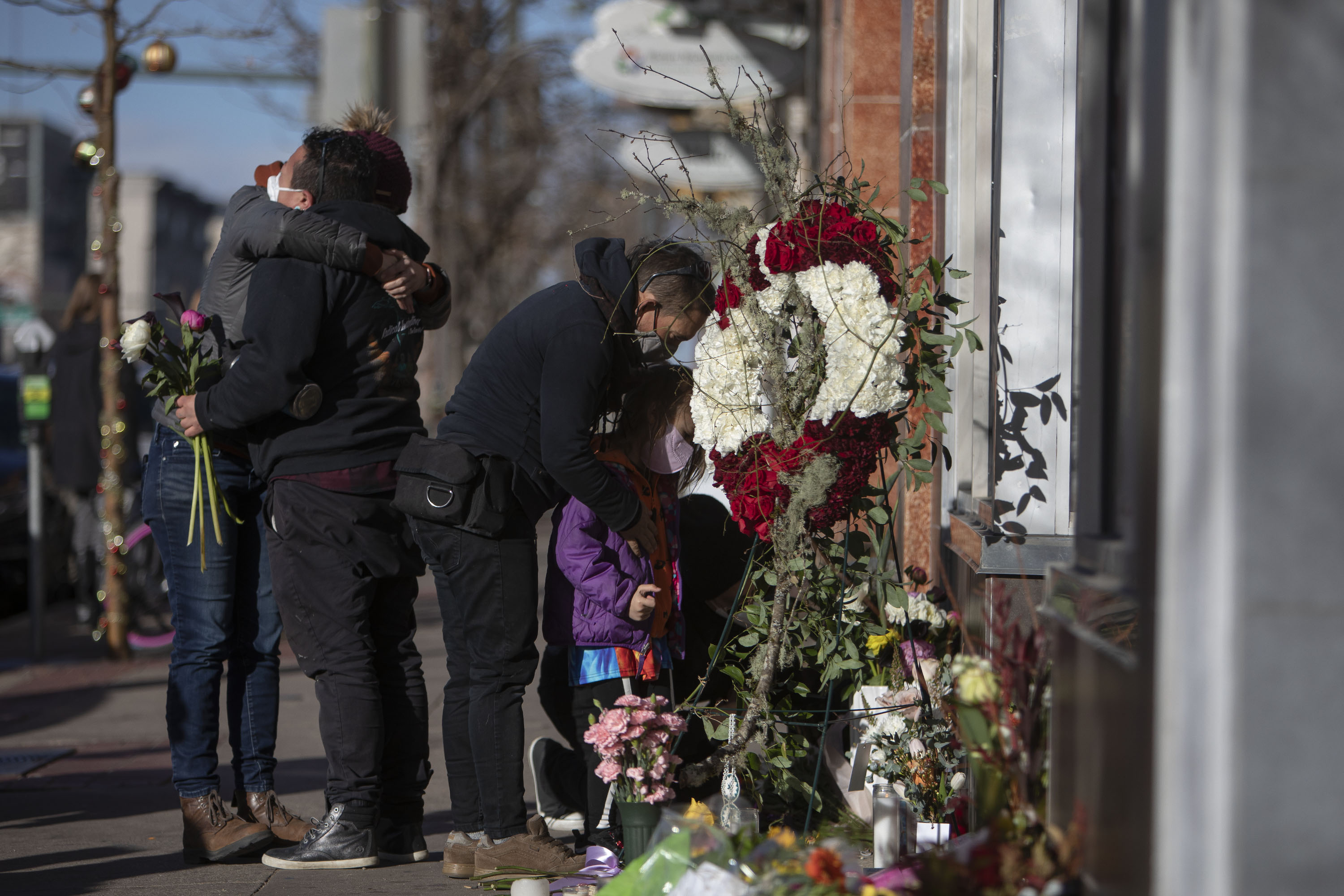 Mourners console one another at a makeshift memorial for slain tattoo shop owner Alicia Cardenas, who was killed in an overnight shooting spree, as seen on Tuesday, Dec. 28, 2021, in Denver, Colo. (Timothy Hurst/The Gazette) (Timothy Hurst)