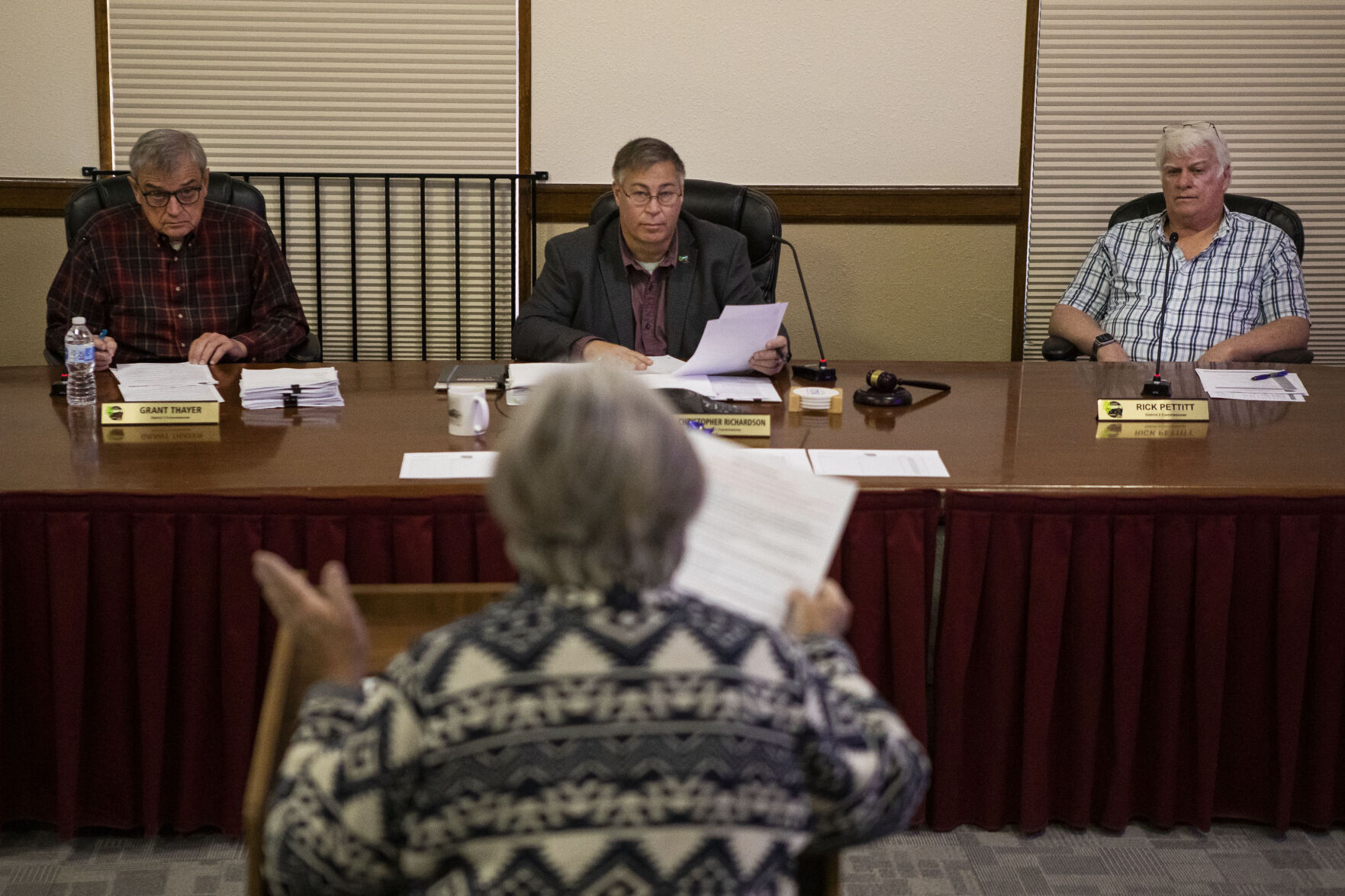 Elbert county commissioners, from left, Grant Thayer, Chris Richardson and Rick Pettitt look onto resident and Elbert County Stands Up member Maggie Witherbee during public comments at a county commissioners’ meeting Wednesday in Kiowa. (PHOTOS BY Timothy Hurst, The Gazette)