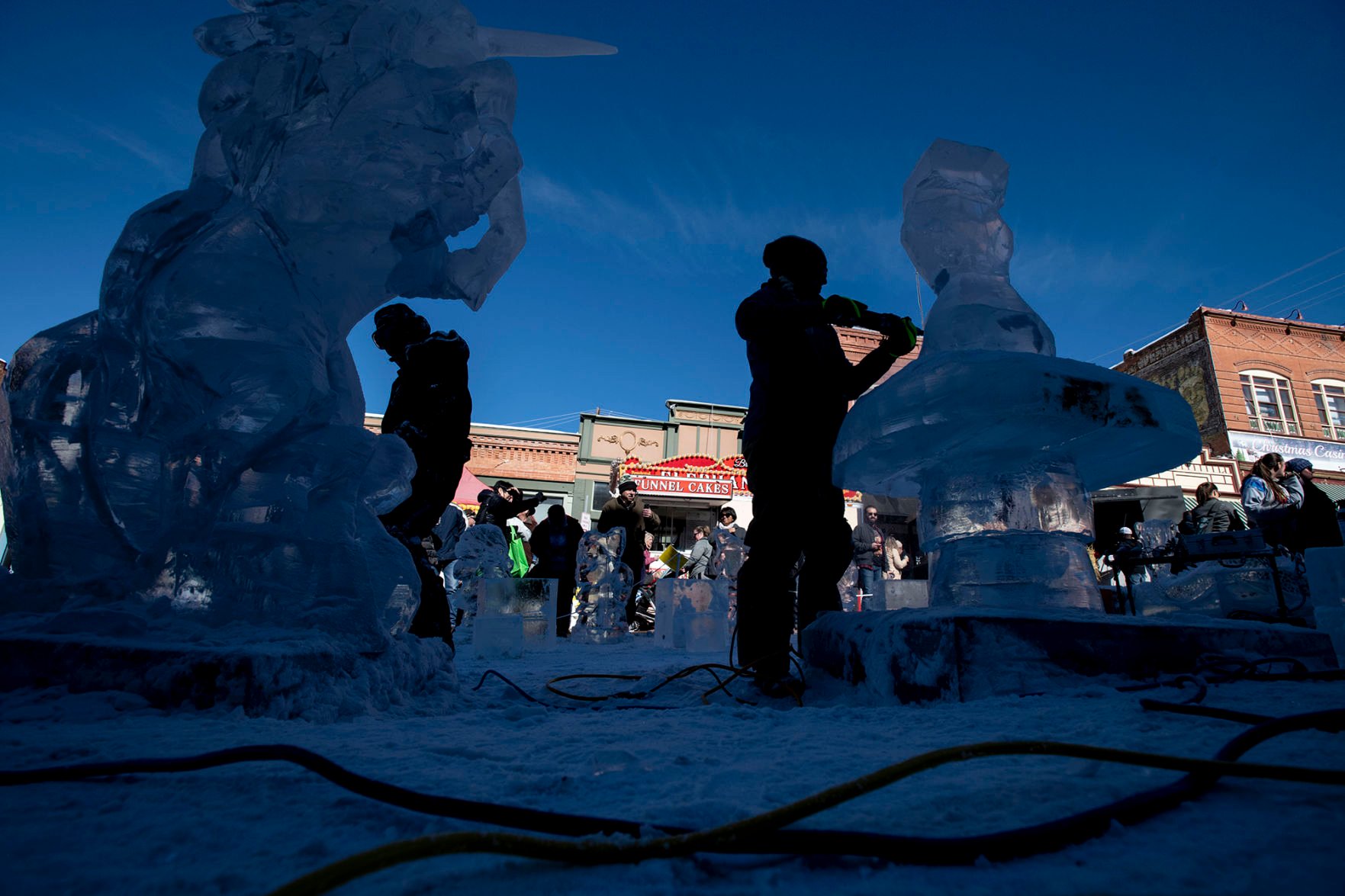 Luan Bui, left, and Julie Eslinger, right, work on their sculptures as part of team Ice Cubed of Denver's Mystical Creatures theme during the 13th annual Cripple Creek Ice Festival in Cripple Creek, Colo., on Saturday, Feb. 8, 2020. This year, ice sculptors will be competing for a “People’s Choice” cash prize, where the public can vote for the best carving. The artists will continue their creations Sunday and next weekend. The winning team will be announced on February 16th. (Chancey Bush/ The Gazette) (Chancey Bush The Gazette)