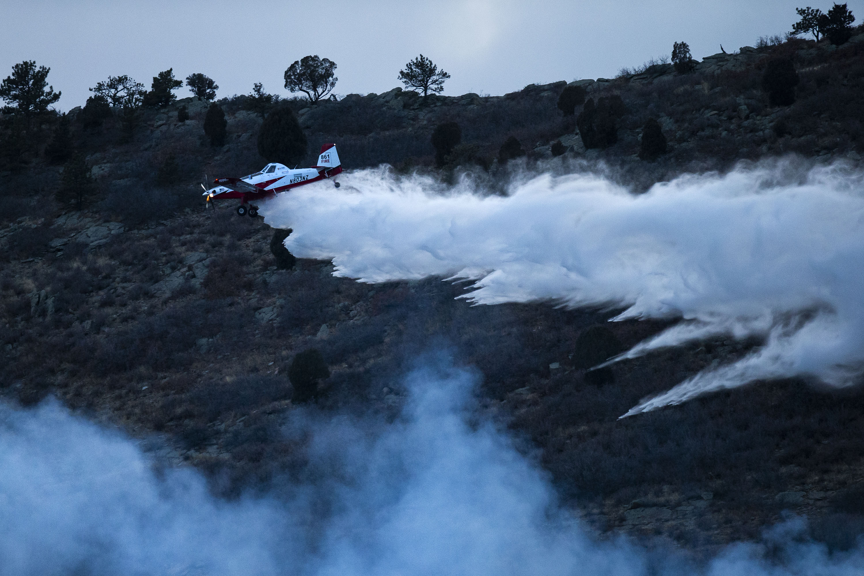 A single engine air tanker makes a drop above a grassfire on the hill west of C-470 on Monday, Dec. 27, 2021, in Littleton, Colo. (Timothy Hurst/The Gazette) (Timothy Hurst)