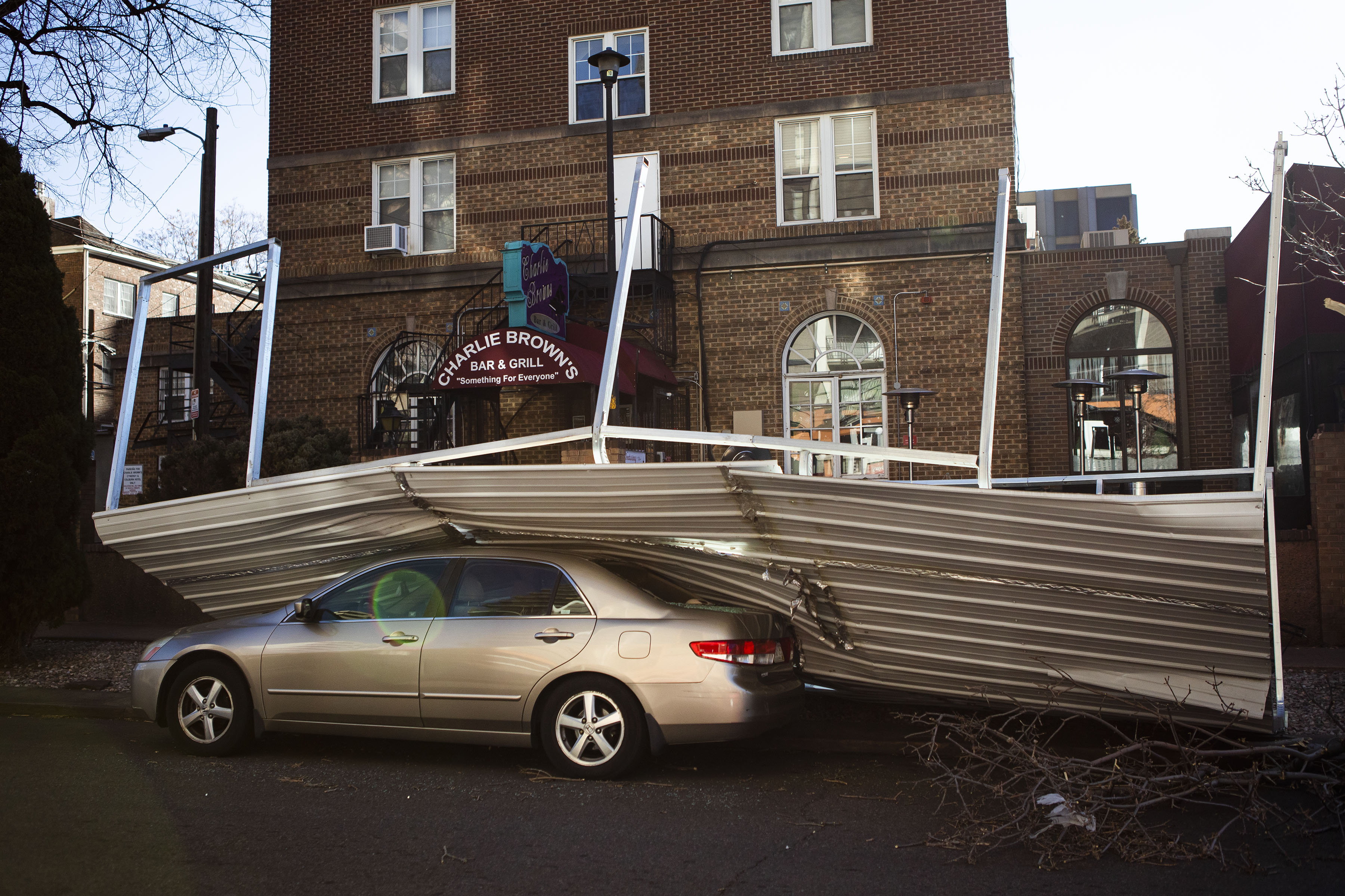A metal roof that blew off the front porch and onto a parked car sits in front of Charlie Brown’s Bar & Grill on Wednesday, Dec. 15, 2021, in Denver, Colo. (Timothy Hurst/The Gazette) (Timothy Hurst)