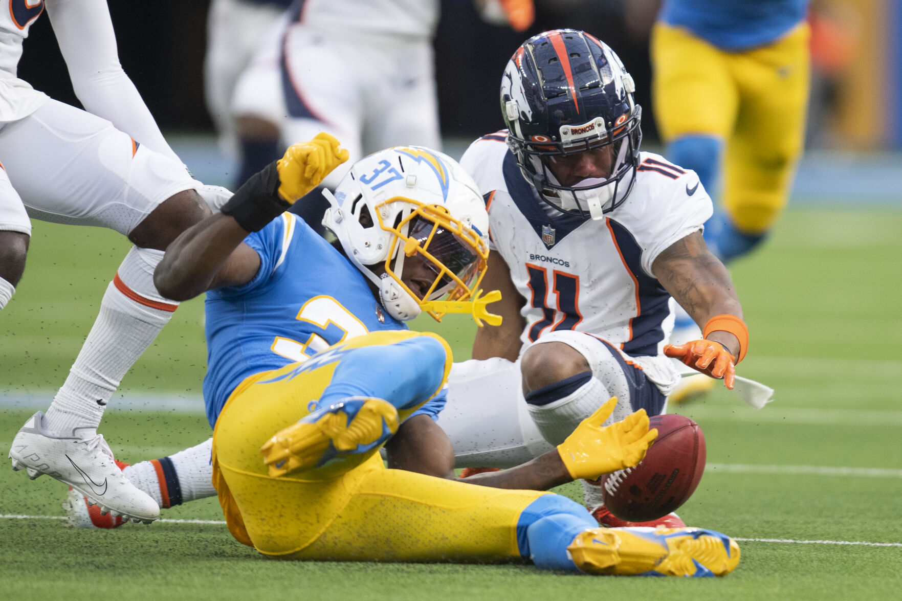 Los Angeles Chargers cornerback Kemon Hall (37) recovers a fumble by Denver Broncos wide receiver Diontae Spencer (11) during an NFL football game Sunday, Jan. 2, 2022, in Inglewood, Calif. (AP Photo/Kyusung Gong)