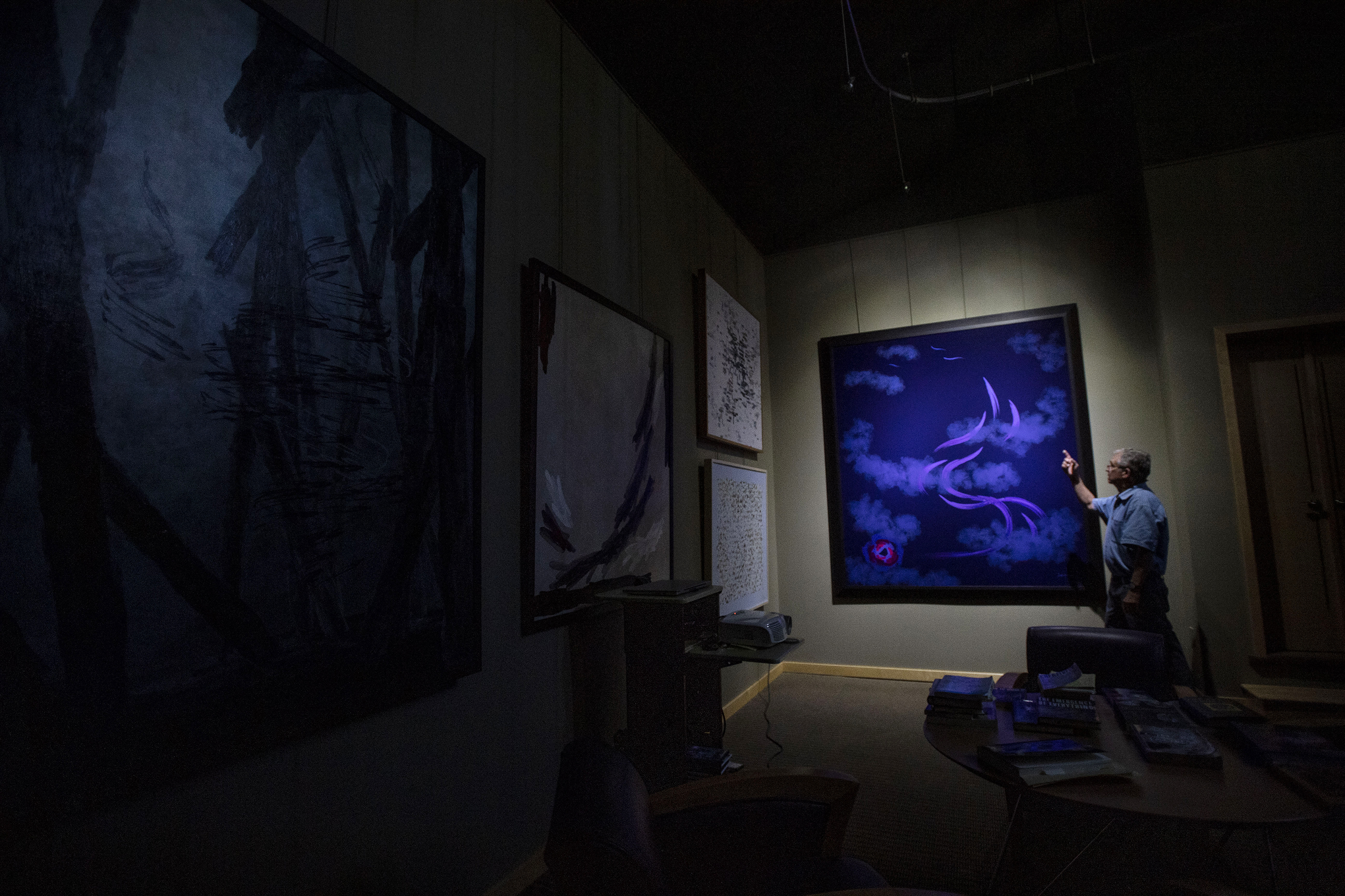 Artist Paul Kirby stands next to a painting produced by Dulcinea, a painting robot he invented, at his studio in Loveland. (Chancey Bush, The Gazette)