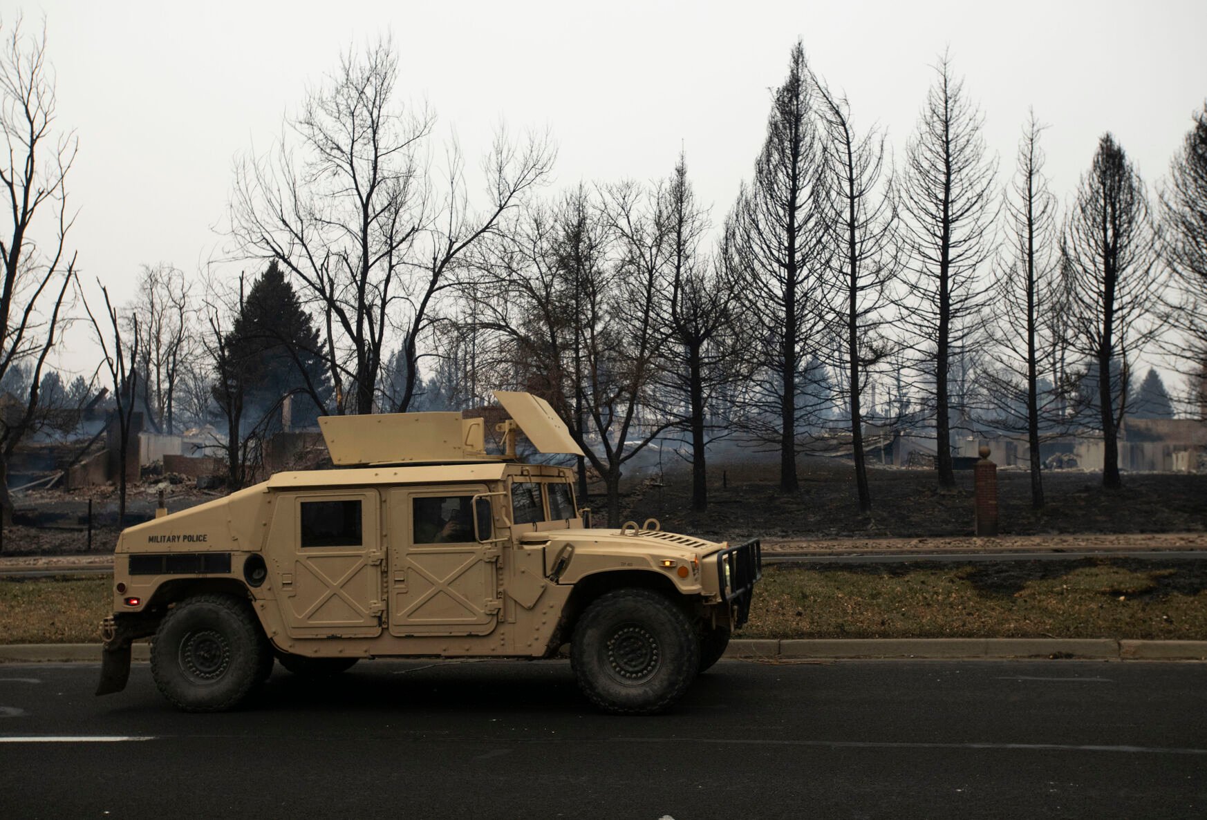 National Guard vehicles drive through the aftermath of the Marshall fire on McCaslin Boulevard in Louisville, Colo., on Friday, Dec. 31, 2021. The Marshall fire ripped through Boulder County fulled by high-winds on Thursday, destroying over 500 homes. The number of destroyed homes will likely increase as approximately 35,000 people were evacuated in Louisville and Superior.(Chancey Bush/ The Gazette) (Chancey Bush/ The Gazette)