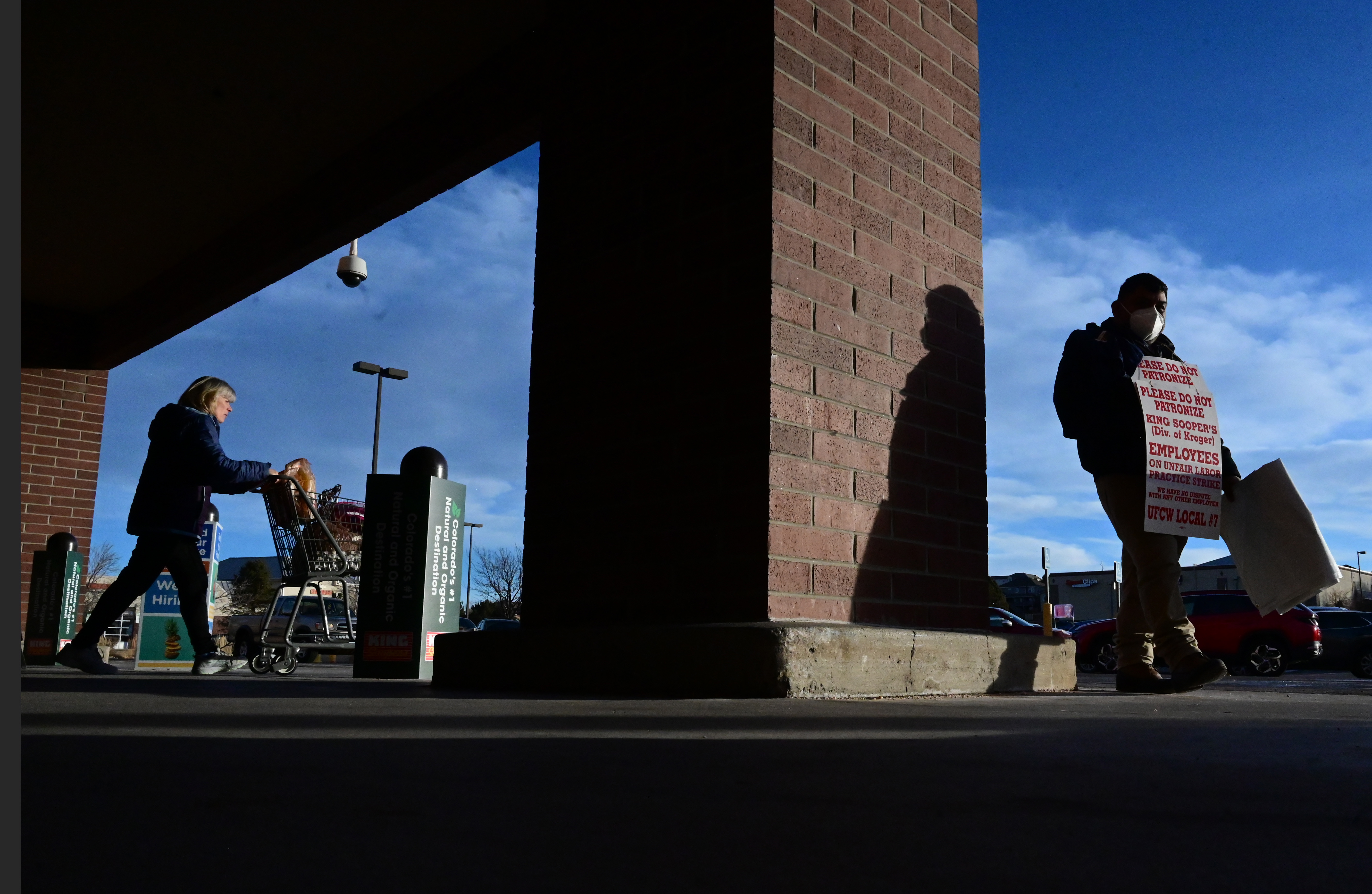 A grocery shopper walks out of King Soopers past protester Rafael Martinez. The union member workers from many metro Denver area King Soopers went on strike at 5 a.m. Wednesday. At the Stroh Ranch King Soopers on south Parker Road in Parker picketers were out in force early Wednesday morning on Jan. 12, 2022. (Photo by Jerilee Bennett, The Gazette) (Jerilee Bennett/The Denver Gazette)