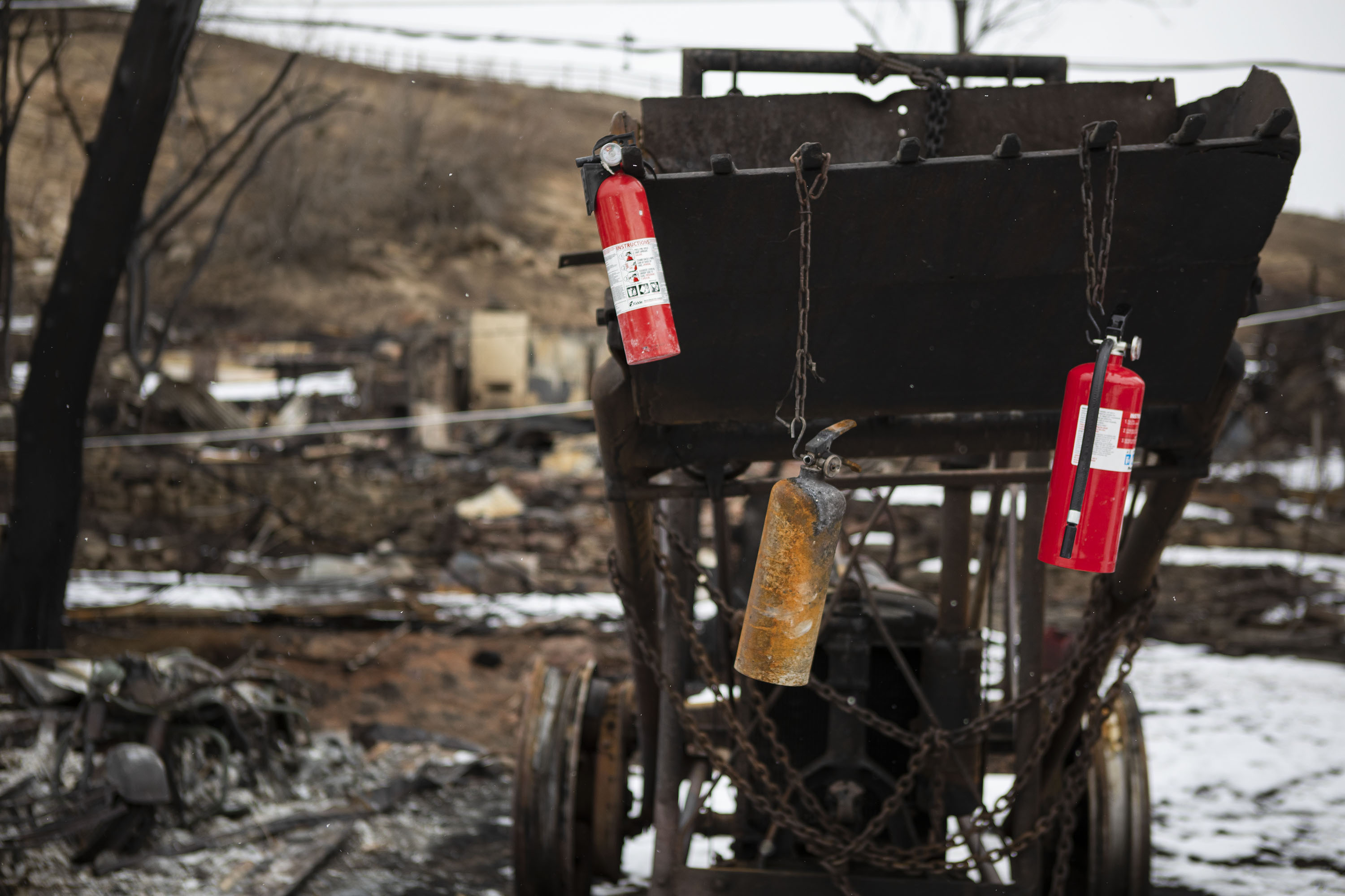 Empty fire extinguishers used by resident Bob Gabriella during the onset of the Marshall Fire hang from a vintage tractor where many of his family’s homes and buildings burned on Marshall Road on Wednesday, Jan. 5, 2022, in unincorporated Boulder County, Colo. (Timothy Hurst/The Gazette) (Timothy Hurst)
