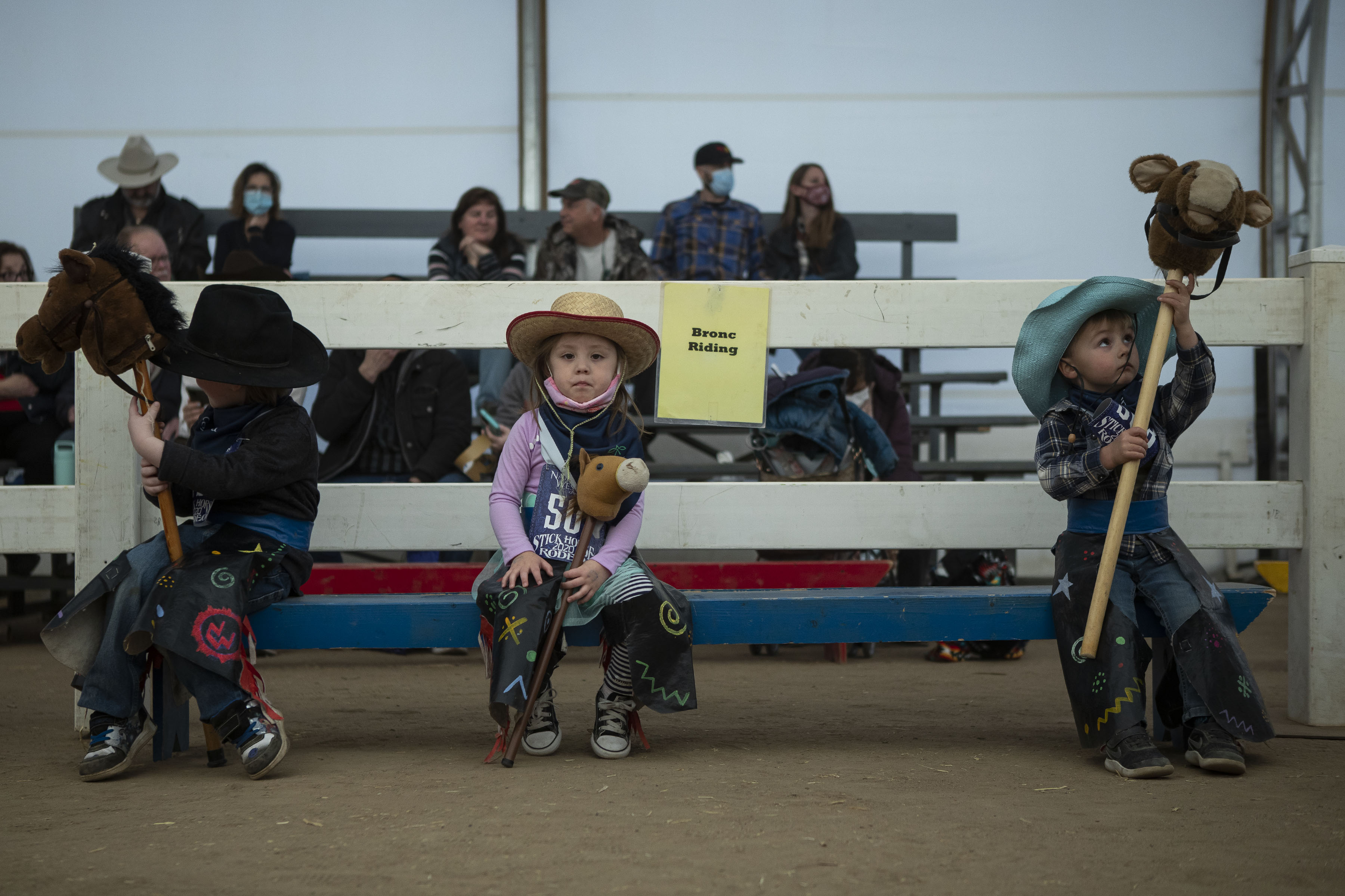 National Western Stick Horse Rodeo participants, from left, Noah Adams, 5, Cadence Saiz, 3, and Eli Brage, 3, wait for their events to begin during a free grounds admission day at the National Western Stock Show on Tuesday, Jan. 11, 2022, in Denver, Colo. (Timothy Hurst/The Gazette) (Timothy Hurst)