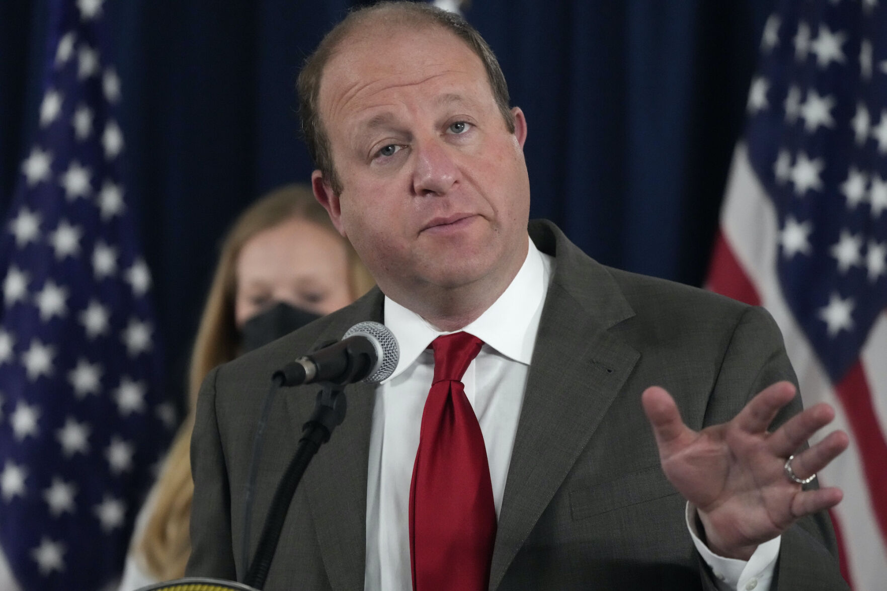 Colorado Governor Jared Polis, front, makes a point as state epidemiologist Rachel Herlihy listens during a news conference on the state’s response to the COVID-19 pandemic on Dec. 7, 2021, in Denver. ((AP Photo/David Zalubowski))