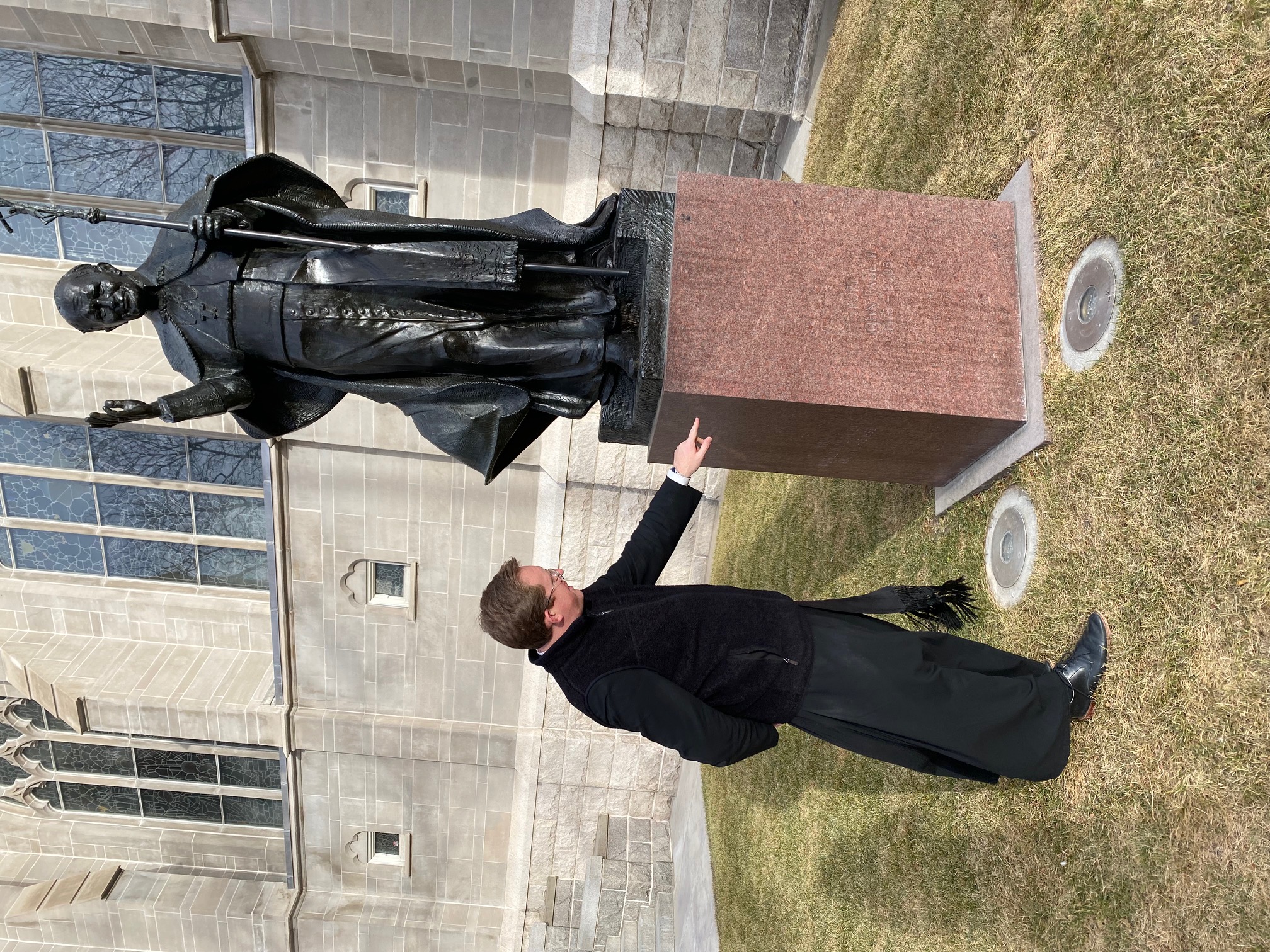 Father Samuel Morehead points to the three-sides of the Pope John Paul II statue which the District Attorney says were spray painted by the suspect. 