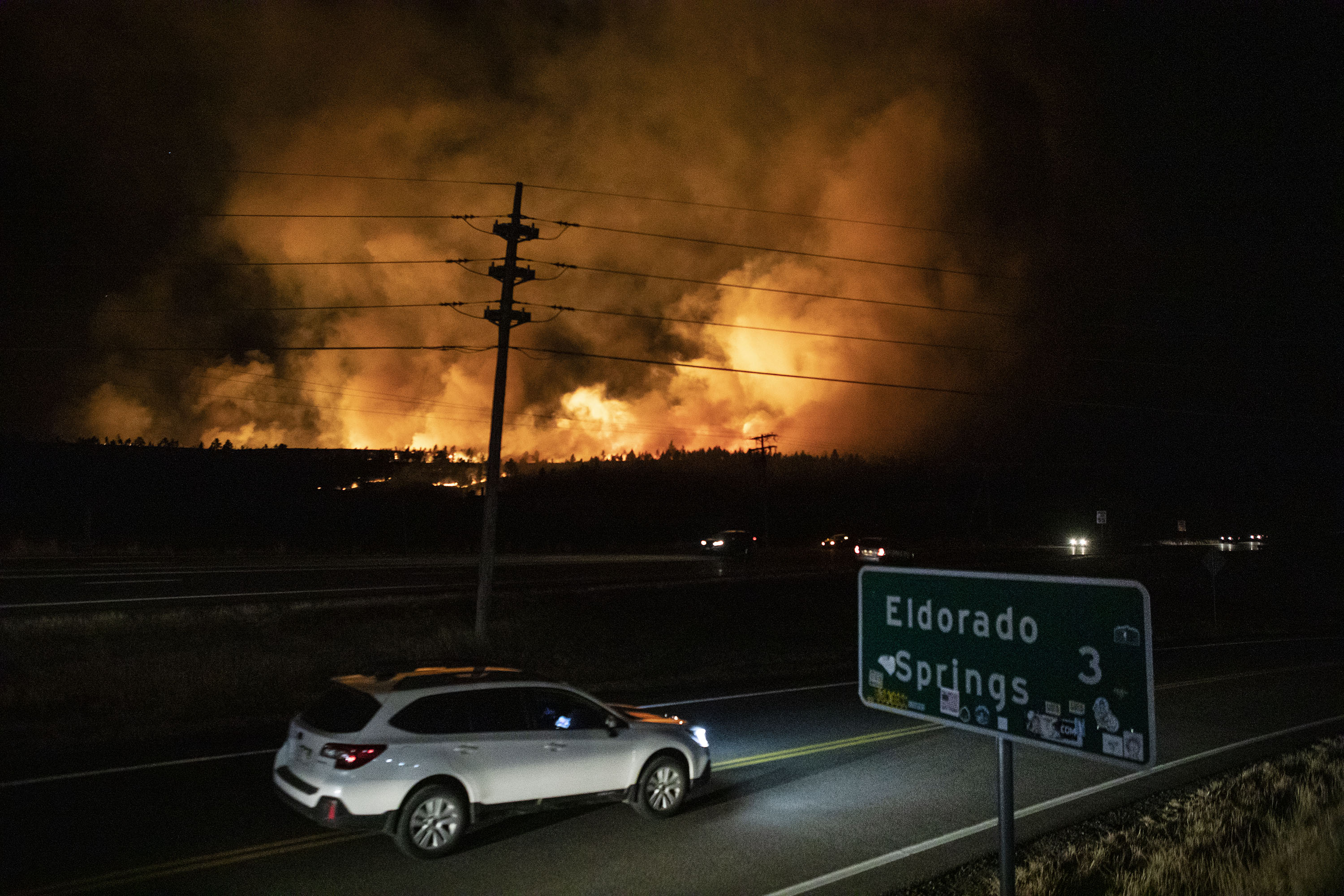 Flames light up the smoke plume as a wildfire moves west down the hill at Marshall Mesa on Thursday, Dec. 30, 2021, near Eldorado Springs, Colo. (Timothy Hurst/The Gazette) (Timothy Hurst)