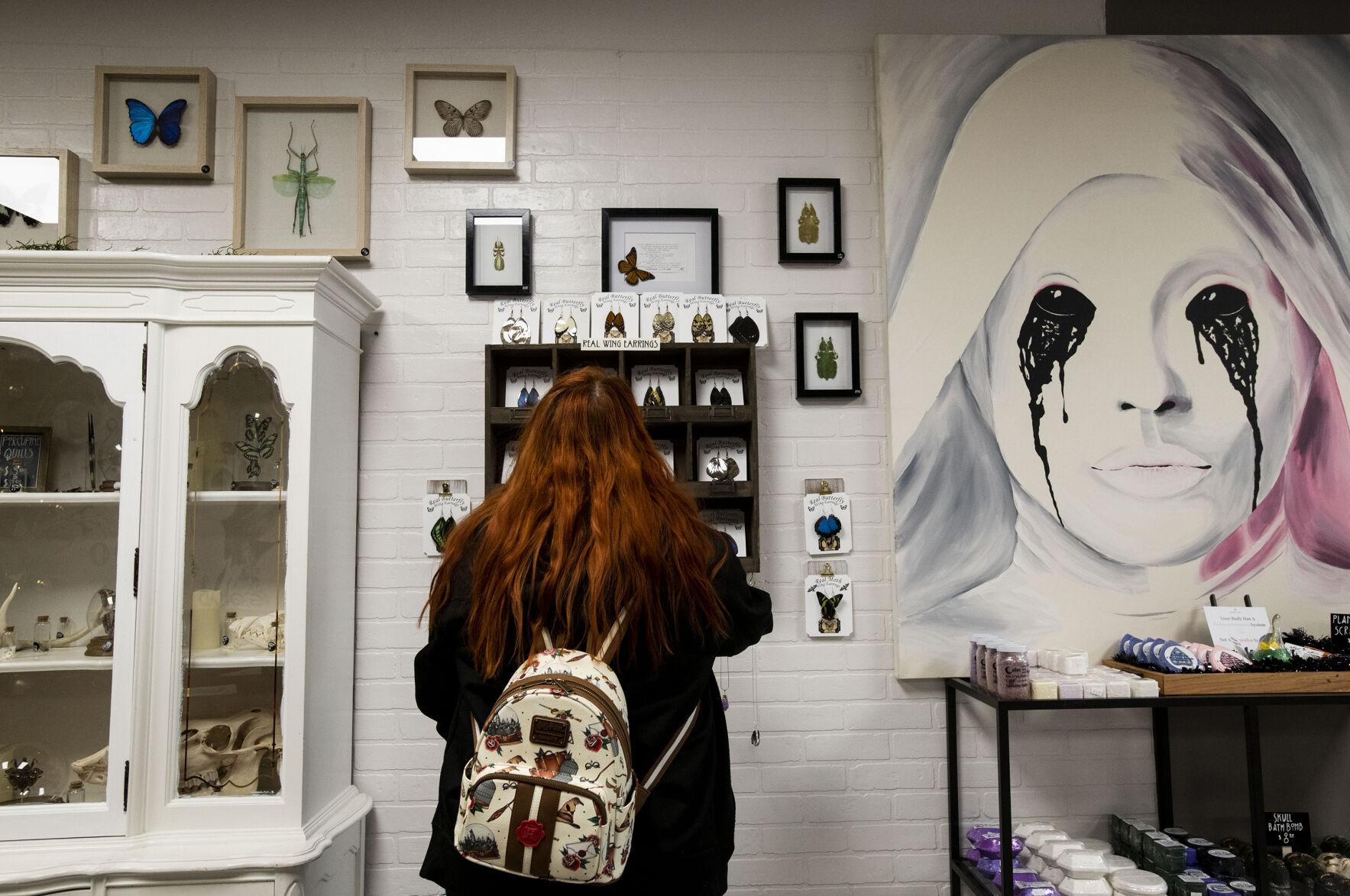 Candice German shops for real butterfly wing earrings made by Andrew Cronk at Cronk Art & Curiosities in downtown Colorado Springs on Saturday, Dec. 18, 2021. Owners Andrew Cronk and his partner Chris Dantzler opened their shop Sept. 30 in a storefront next to The Old Depot on Sierra Madre Street in Colorado Springs. Cronk’s passion for insects and art has led him specialize in ethically-sourced arthropod taxidermy while spreading the message about the importance of pollinators. (Chancey Bush, The Gazette)