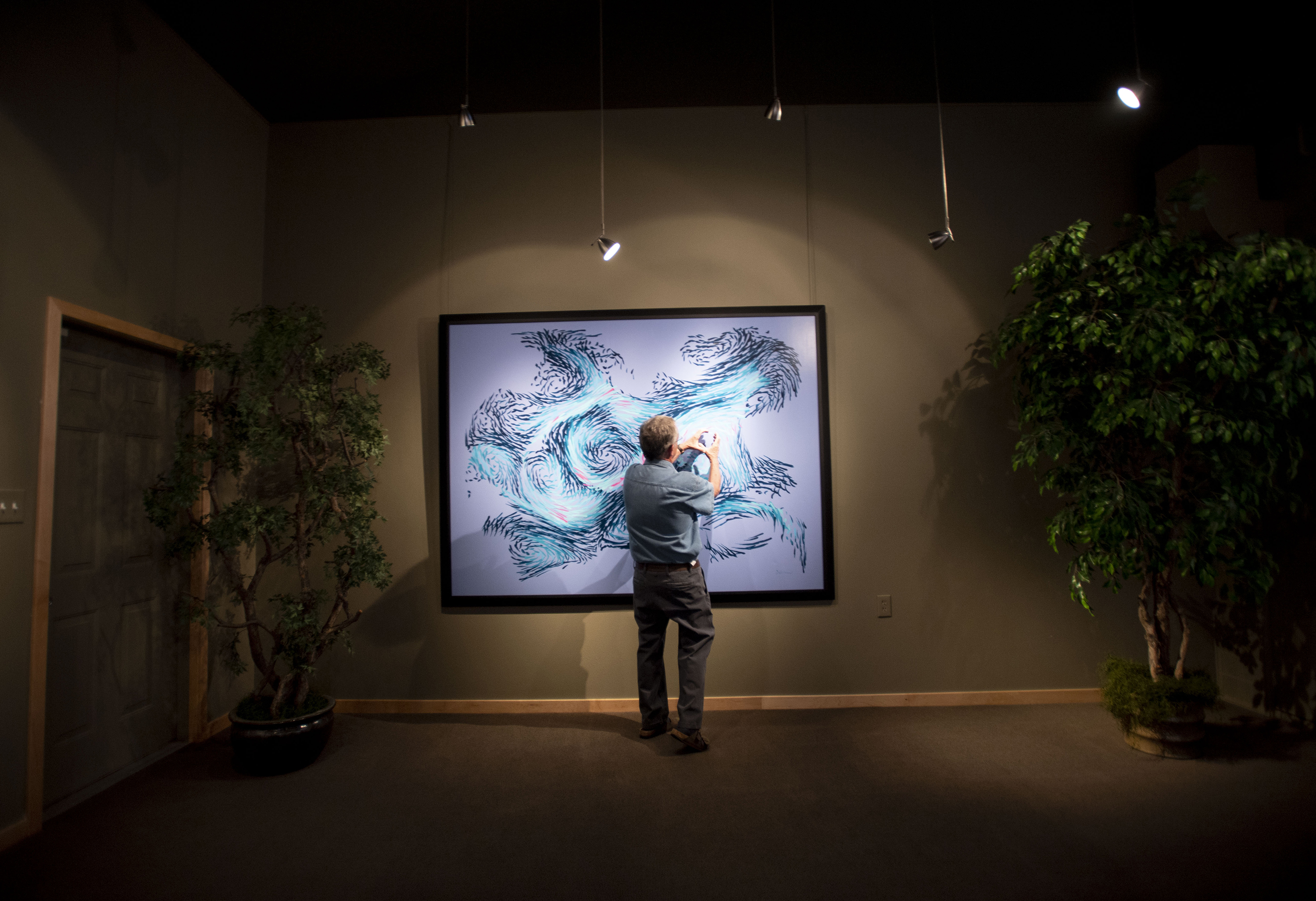 Artist Paul Kirby describes the process behind one of the paintings produced by Dulcinea, a robot he invented that paints one-of-a-kind art. (photos by Chancey Bush, The Gazette)