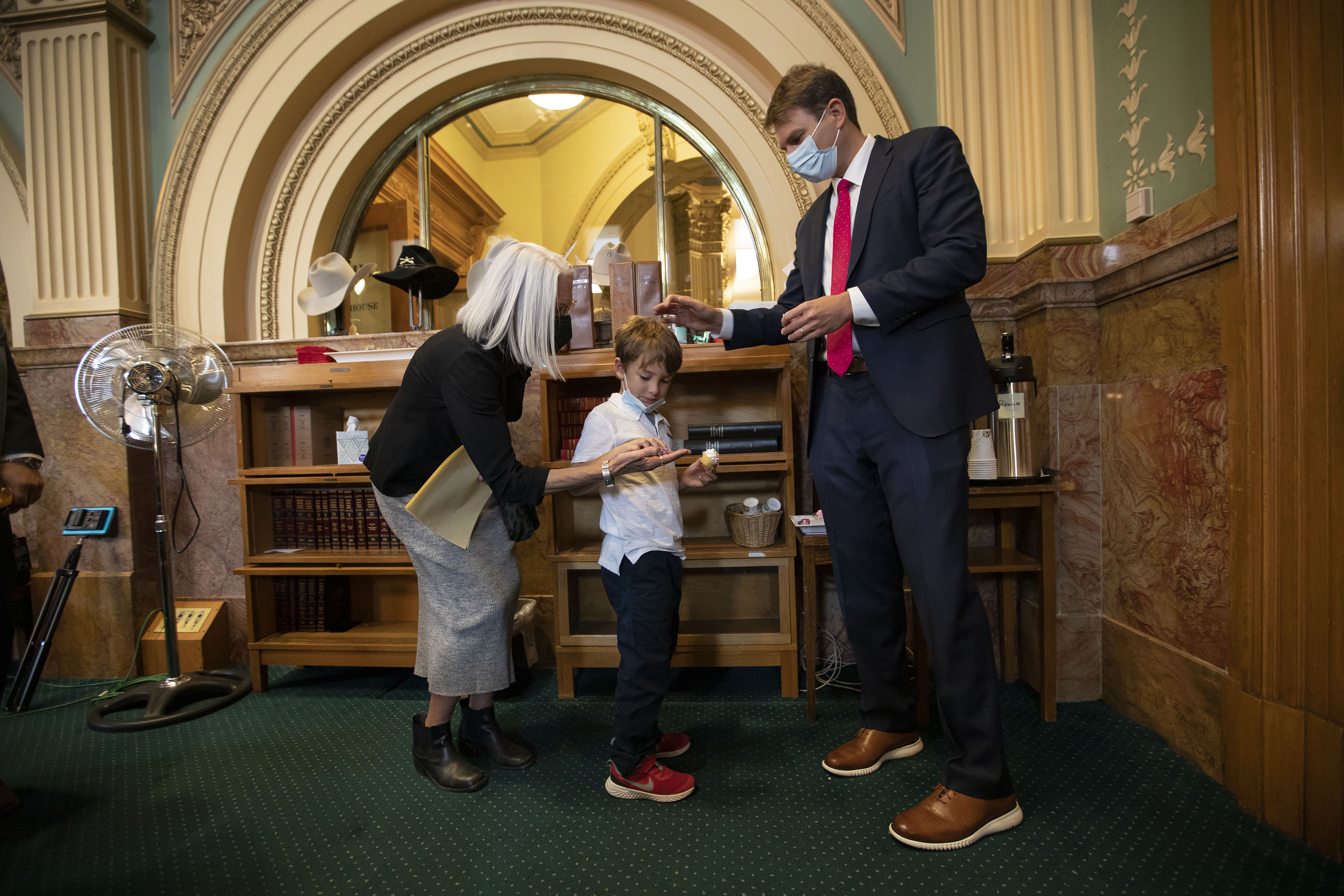 Speaker of the House Rep. Alec Garnett pats son Ashton Garnett’s head while mother Brenda Garnett hands a piece of chocolate to her grandson during a recess in the first day of Colorado’s 2022 session at the Colorado State Capitol building on Wednesday, Jan. 12, 2022, in Denver, Colo. (Timothy Hurst/The Gazette) (Timothy Hurst/The Gazette)