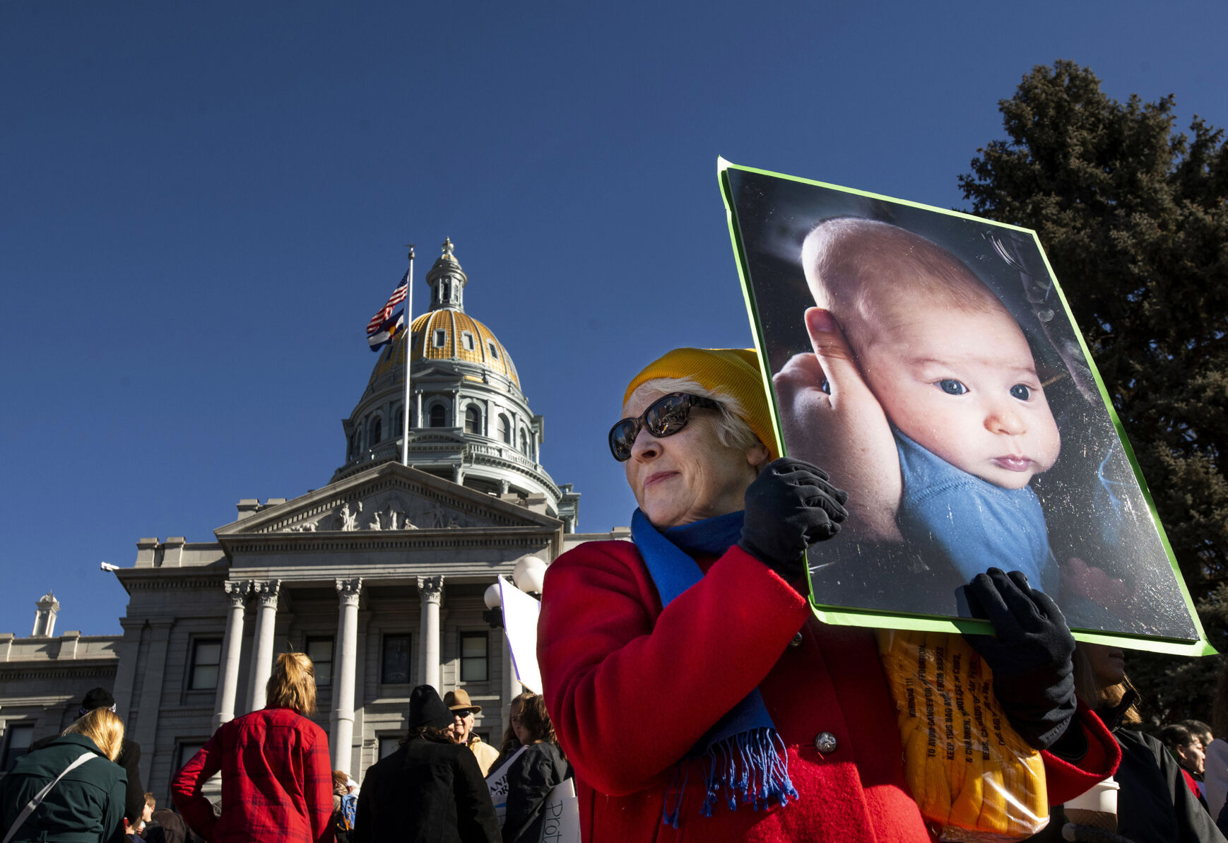 Peggy Caldwell of Denver holds a photo of an infant Saturday during the Celebrate Life Rally and March, hosted by the Archdiocese of Denver and Respect Life Denver, at the state Capitol building in Denver. Thousands attended the annual event honoring courageous mothers. (photos by Chancey Bush, The Gazette)