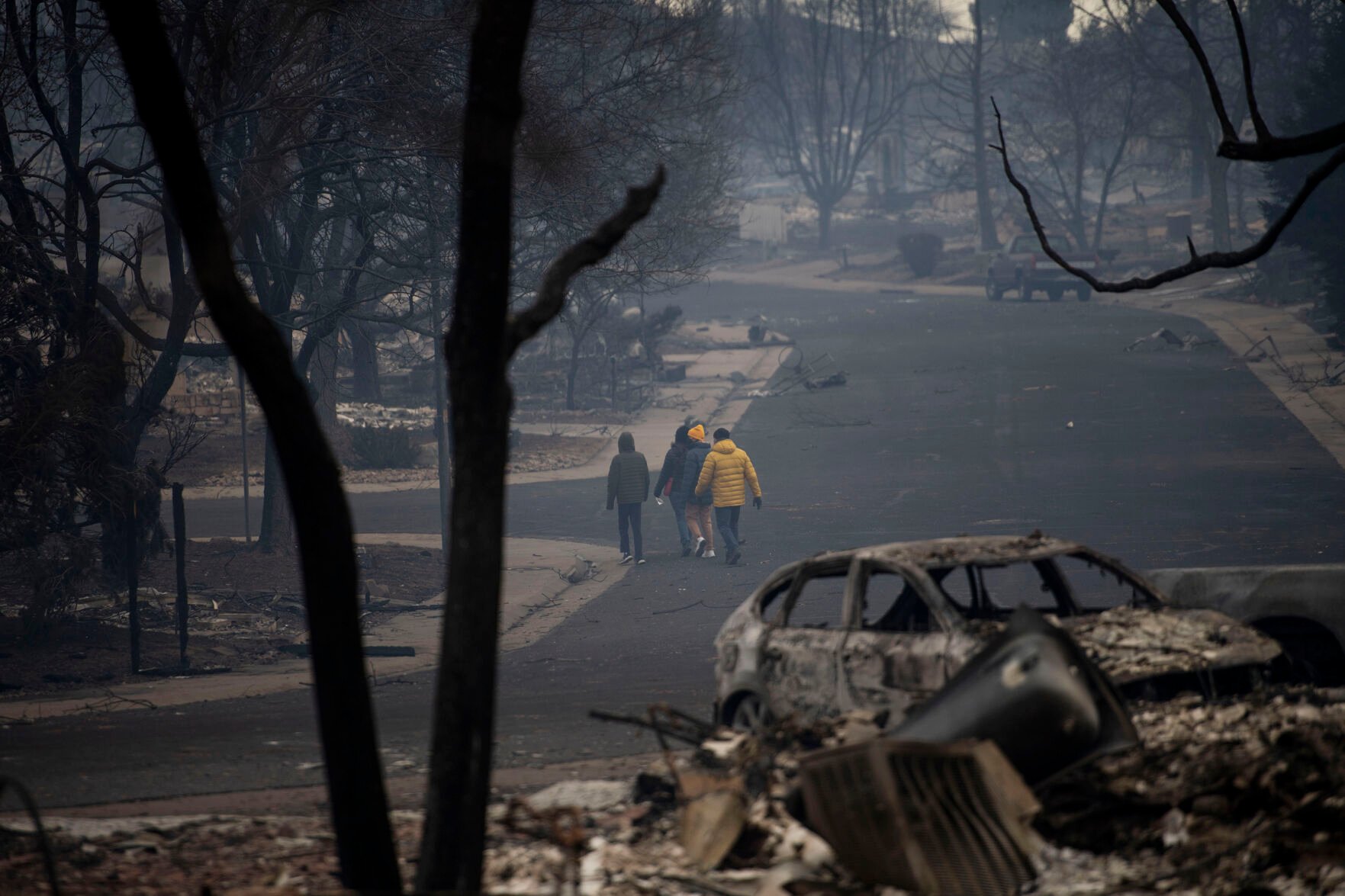 FILE PHOTO: People walk though the destruction across from Davidson Mesa Open Space in Louisville, Colo., on Friday, Dec. 31, 2021. The Marshall fire ripped through Boulder County, fueled by high winds on Thursday, Dec. 30, 2021 and destroying nearly 1,000 homes. Approximately 35,000 people were evacuated in Louisville and Superior. (Chancey Bush/ The Gazette) (Chancey Bush/ The Gazette)