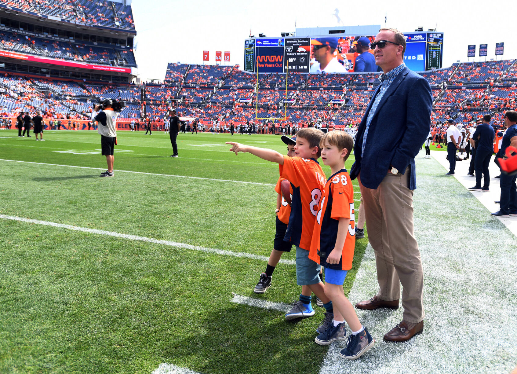 Bronco Superbowl quarterback and future Hall of Famer Peyton Manning made a visit down to the field before the Broncos-Raiders. His son, Marshall Manning (center) points a few things out to his buddies. Interesting that Marshall Manning wears the jersey of Broncos wide receiver Demaryius Thomas. (Photo by Jerilee Bennett, The Gazette)