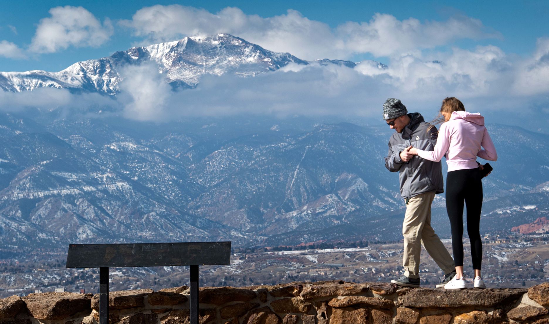 Andrew Irvine and Jessica Hawkins stand on the stone border of the Grandview Overlook in Palmer Park in February to get a better view of 14,115-foot Pikes Peak and downtown Colorado Springs as clouds begin to build over the mountain. Changes in laws regarding American Indian heritage, along with a recent name change of another Colorado mountain to an American Indian name, has helped give momentum to a movement to change Pikes Peak’s name. (ChristianMurdockchristian.murdock@gazette.comhttps://secure.gravatar.com/avatar/7b418fa9a684d03a433f79e3e5065029?d=mm&r=g)